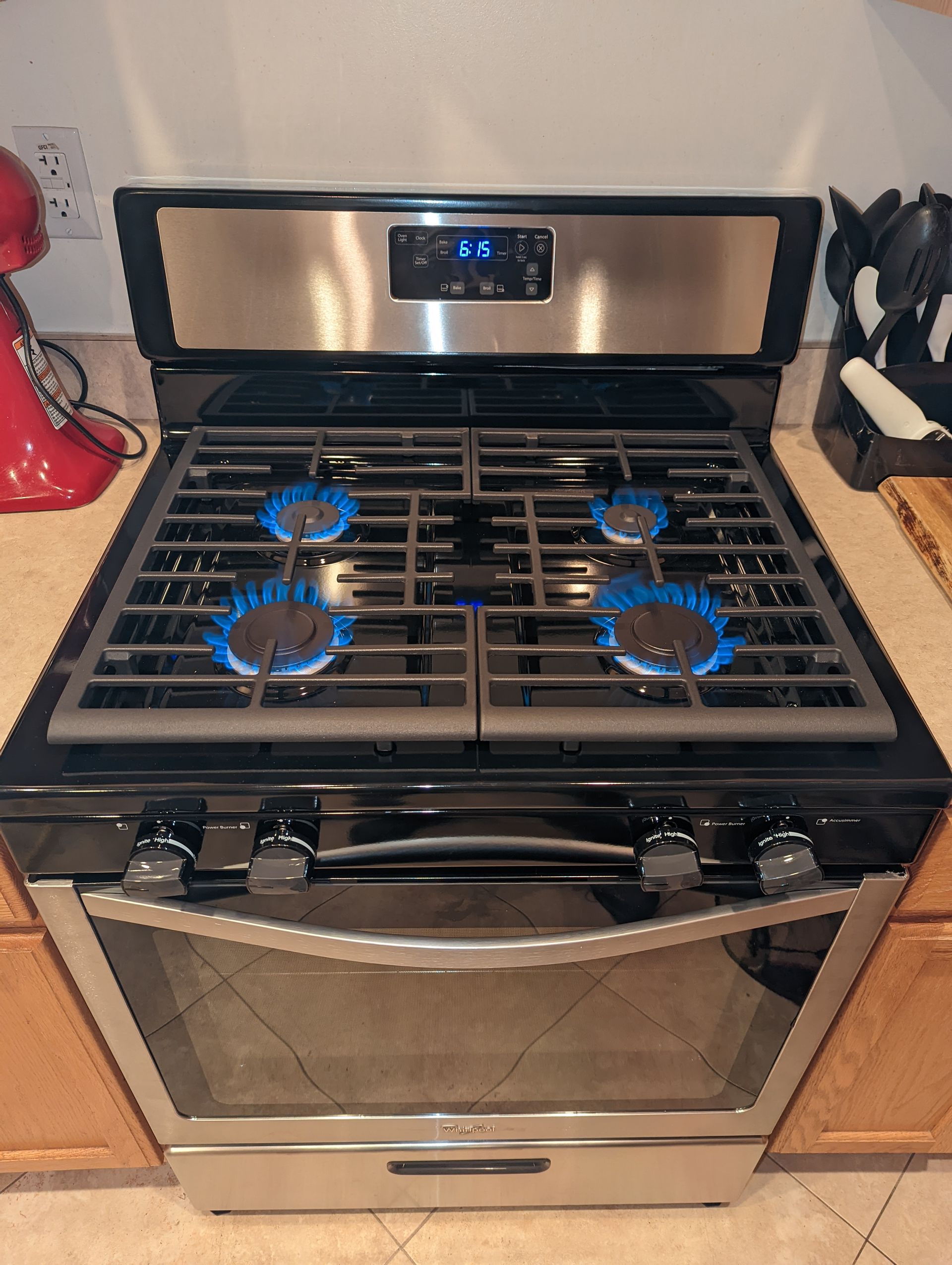 A gas stove with four burners is on a kitchen counter.
