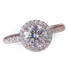 Diamond ring with a round center stone and a halo of smaller diamonds.