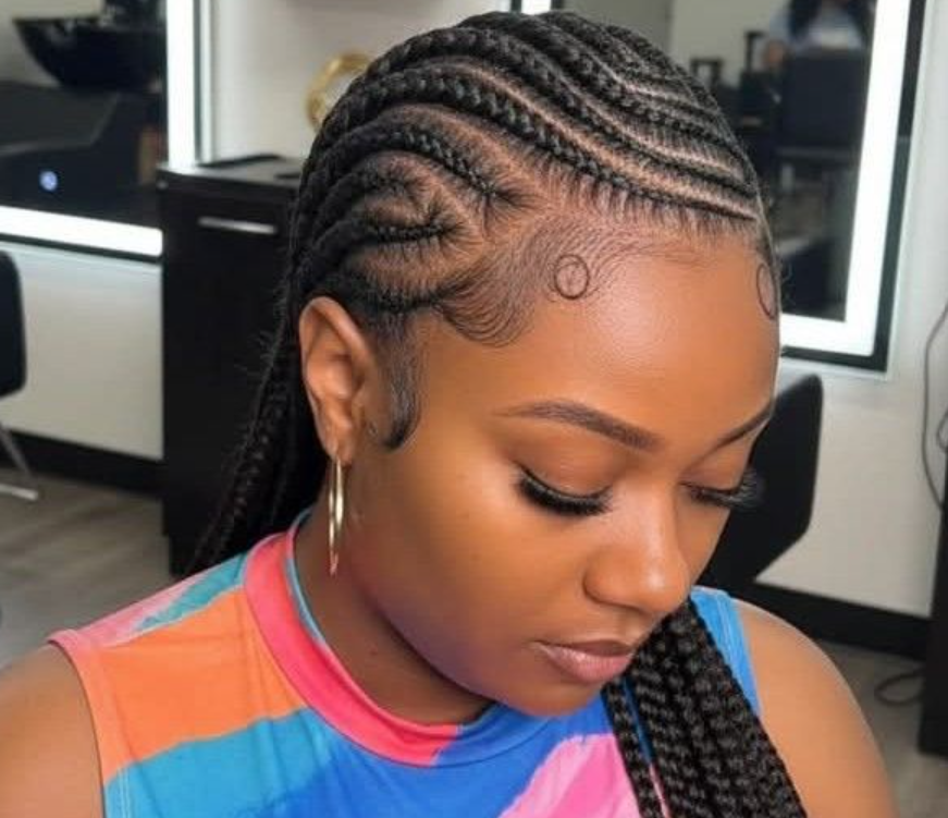 Woman with braided hairstyle, patterned with circular and wavy braids, and laid baby hairs.