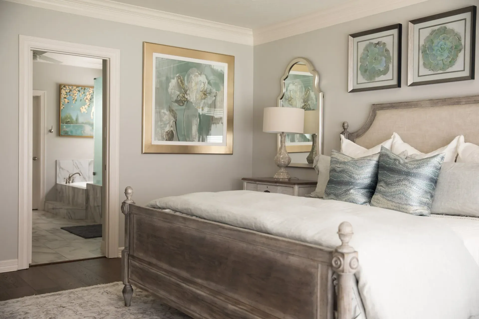 Elegant bedroom with a gray upholstered bed, soft neutral decor, and framed wall art