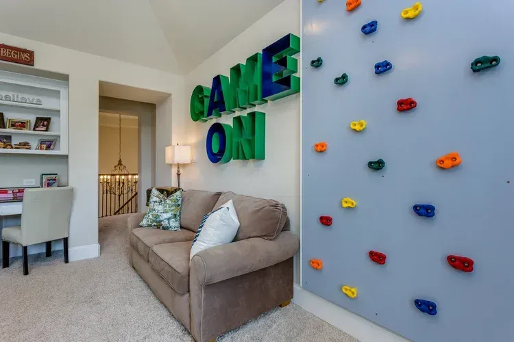 Cozy living room with a beige sofa, built-in shelves, and colorful wall-mounted toy cars