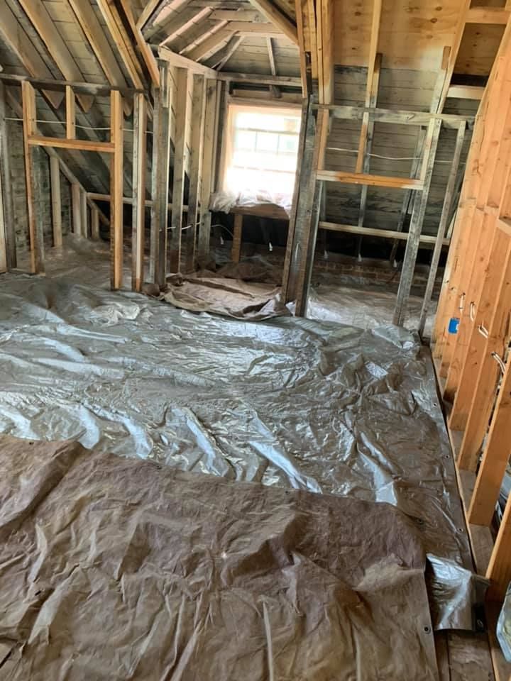 A room in a house under construction with a lot of plastic on the floor.