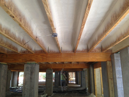 The ceiling of a building under construction with wooden beams.