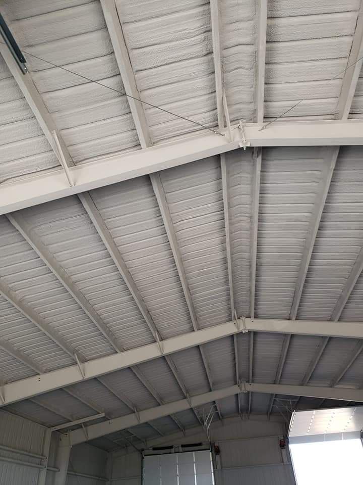 The ceiling of a large building with a white roof.