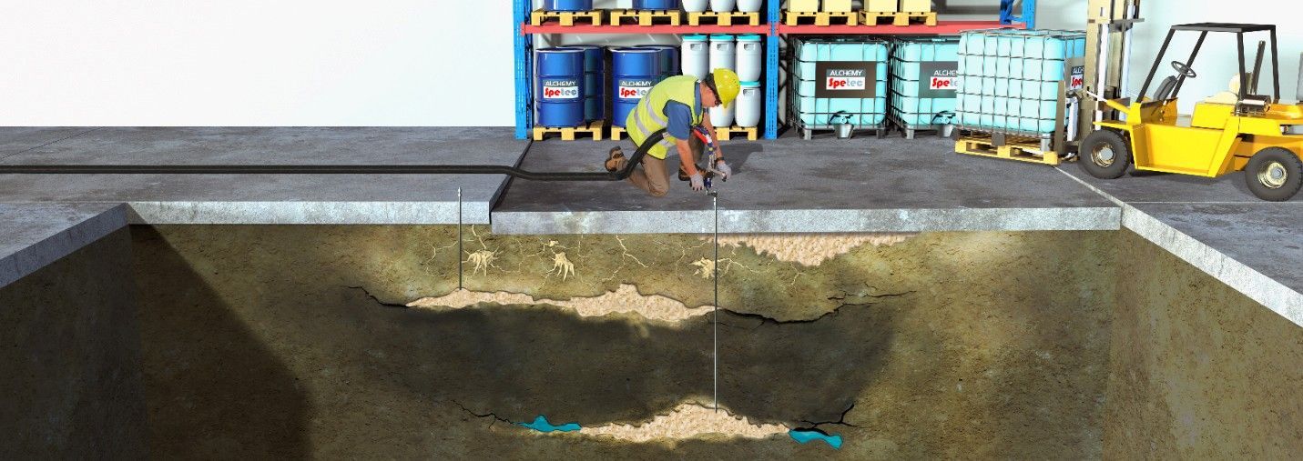 Worker in a warehouse, inspecting the soil, possibly for leaks or environmental contamination. Yellow forklift nearby.