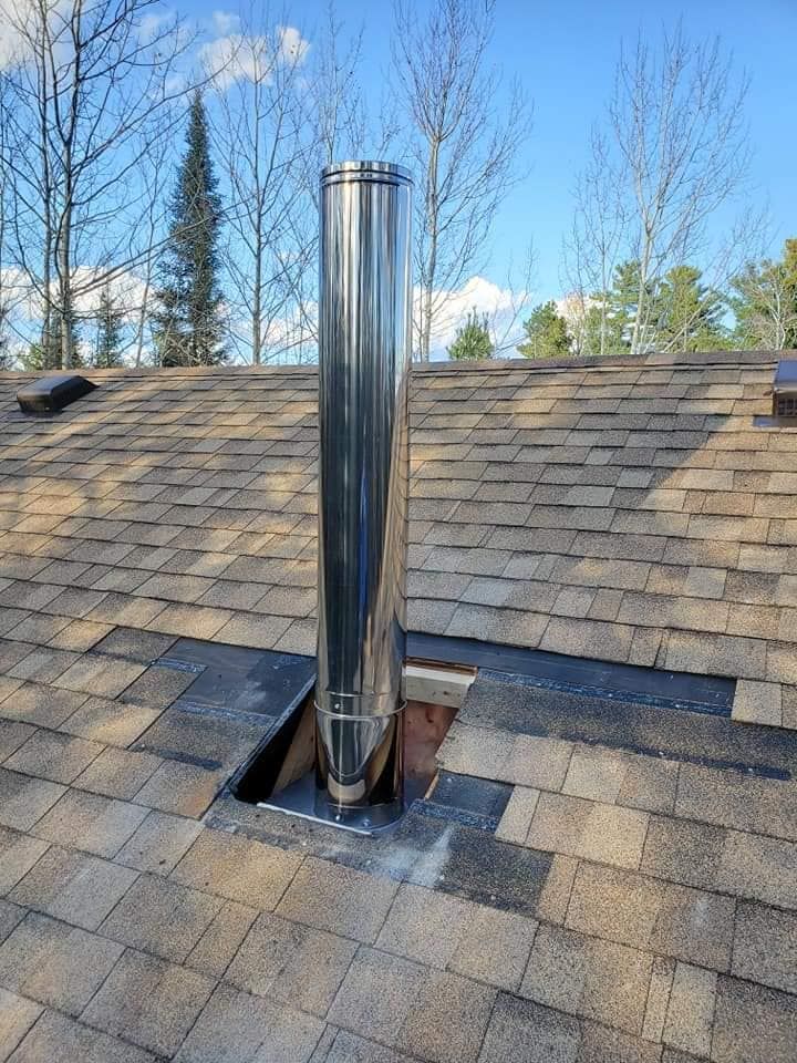 A stainless steel chimney is sitting on top of a roof.