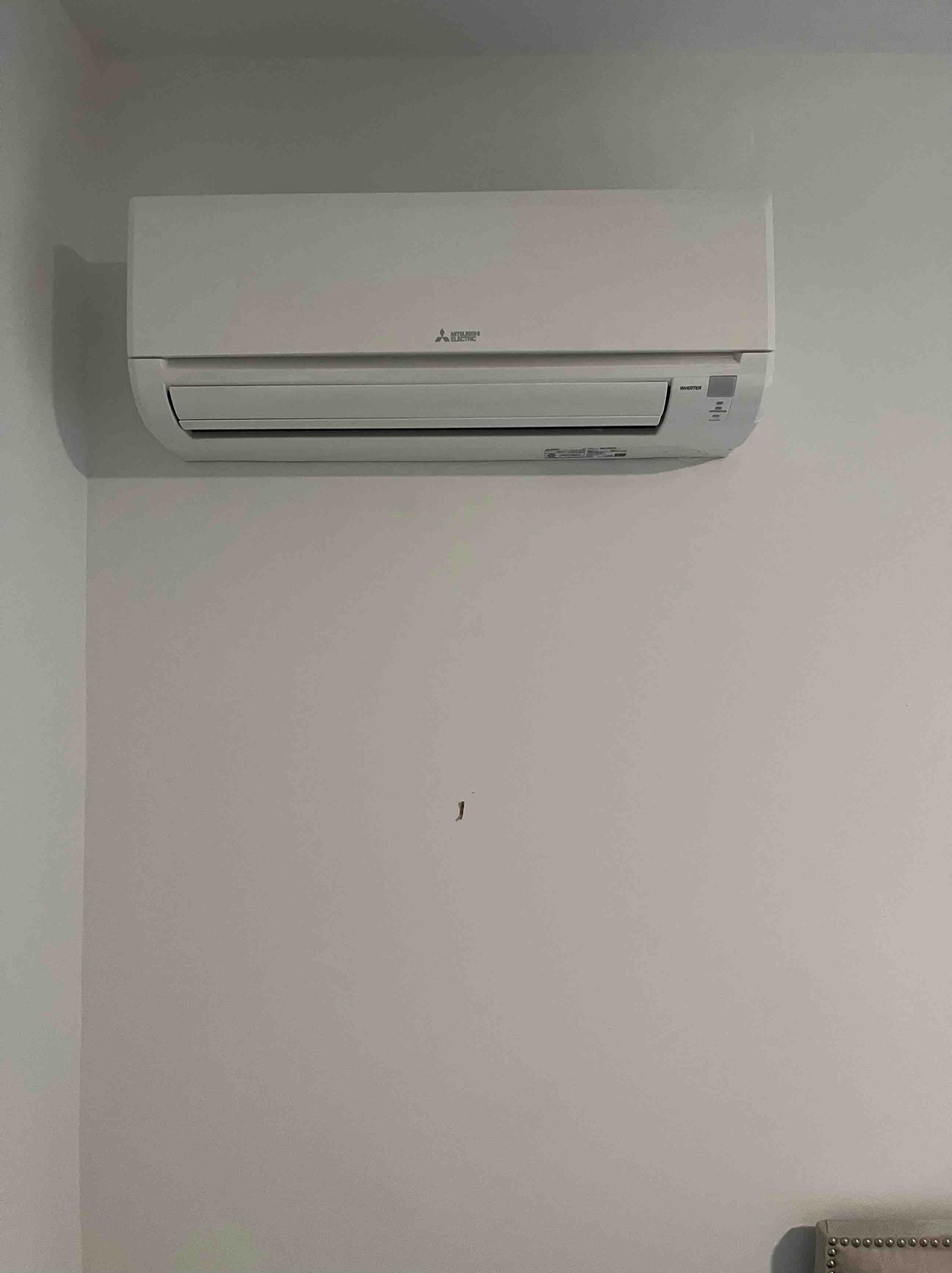 White wall-mounted Mitsubishi air conditioner unit.