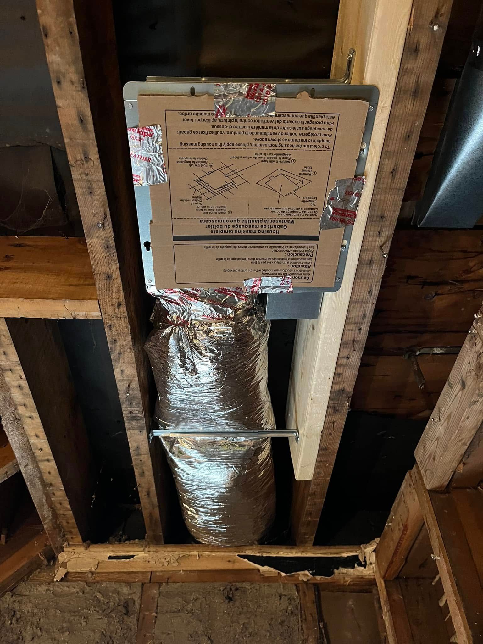 HVAC ductwork in a wooden structure. Silver flexible ducting connects to a rectangular metal component.