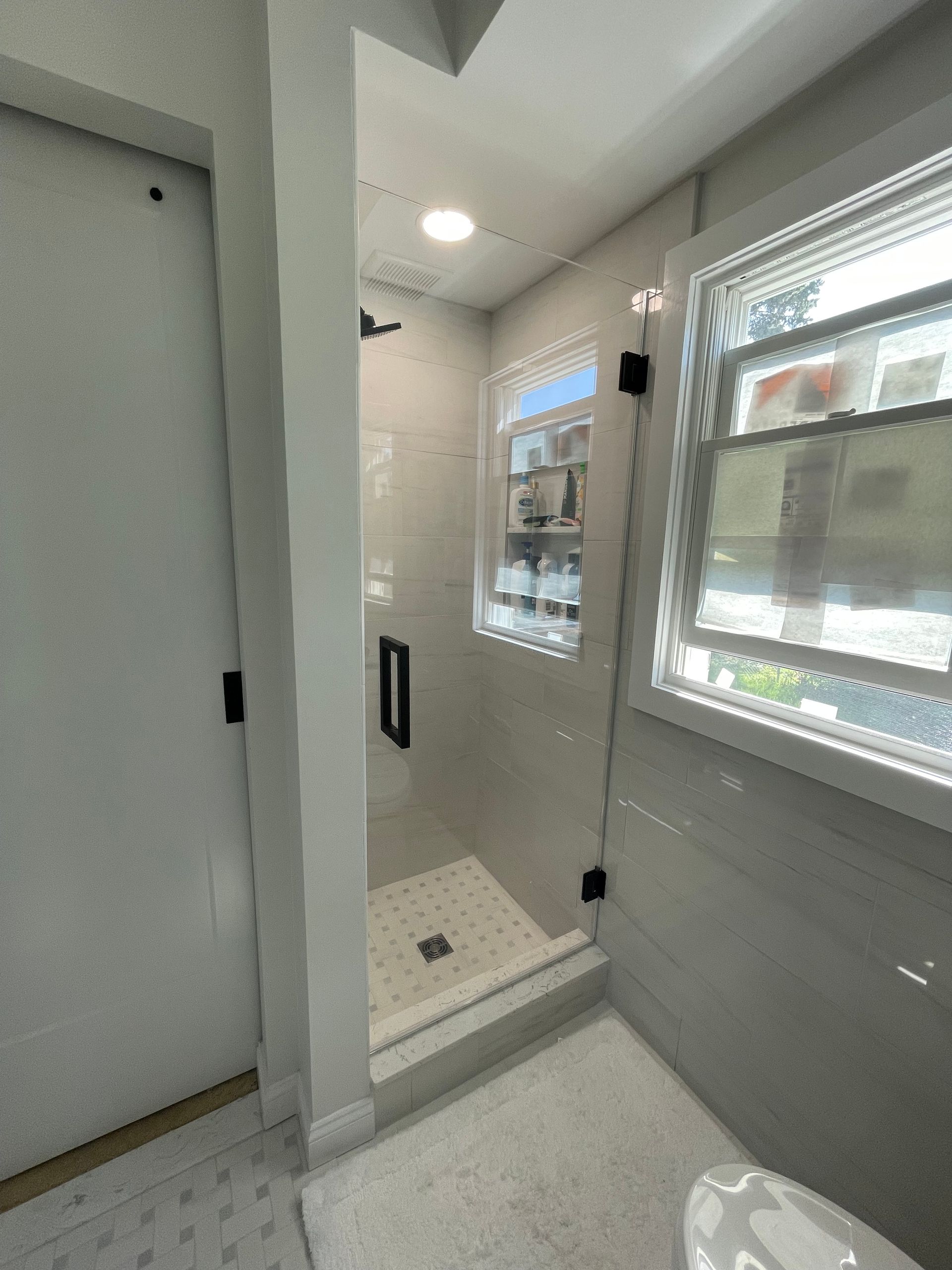 A bathroom with a sink , shower , and mirror.