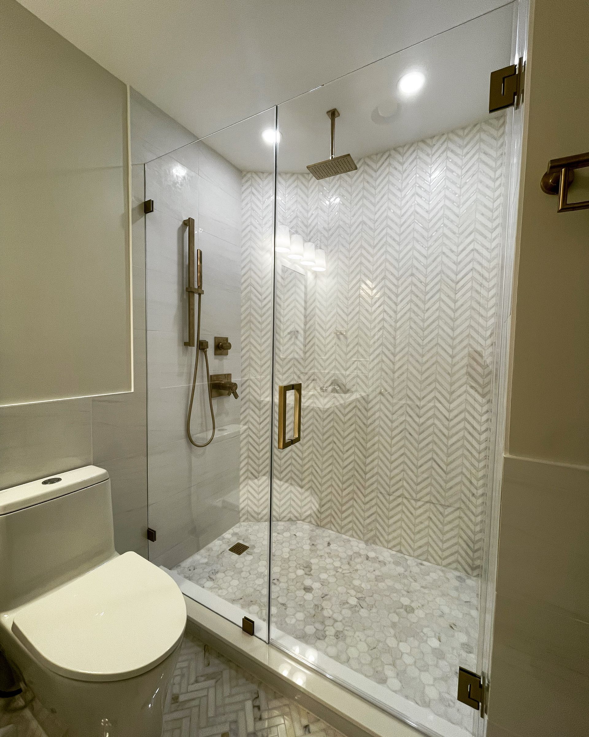 A bathroom with a toilet and a shower with a glass door