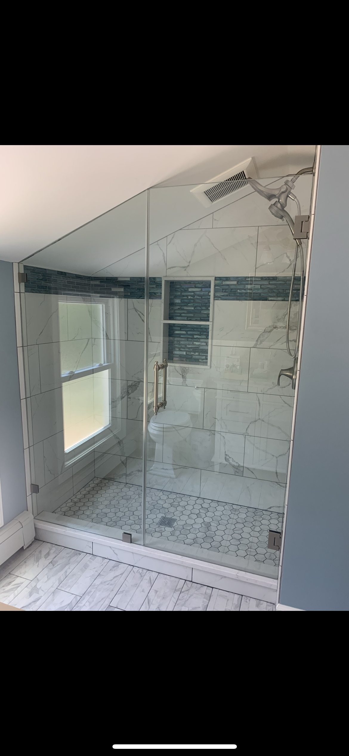 A bathroom with a large mirror on the wall and a window.