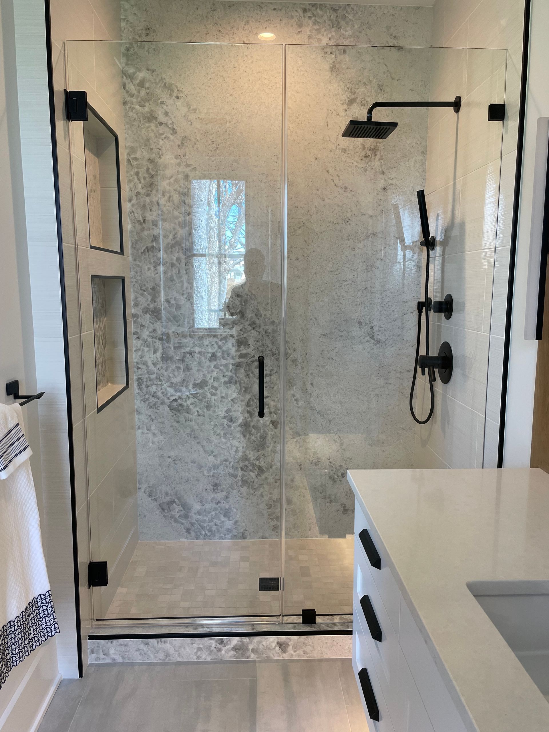 A bathroom with a walk in shower and a sink.