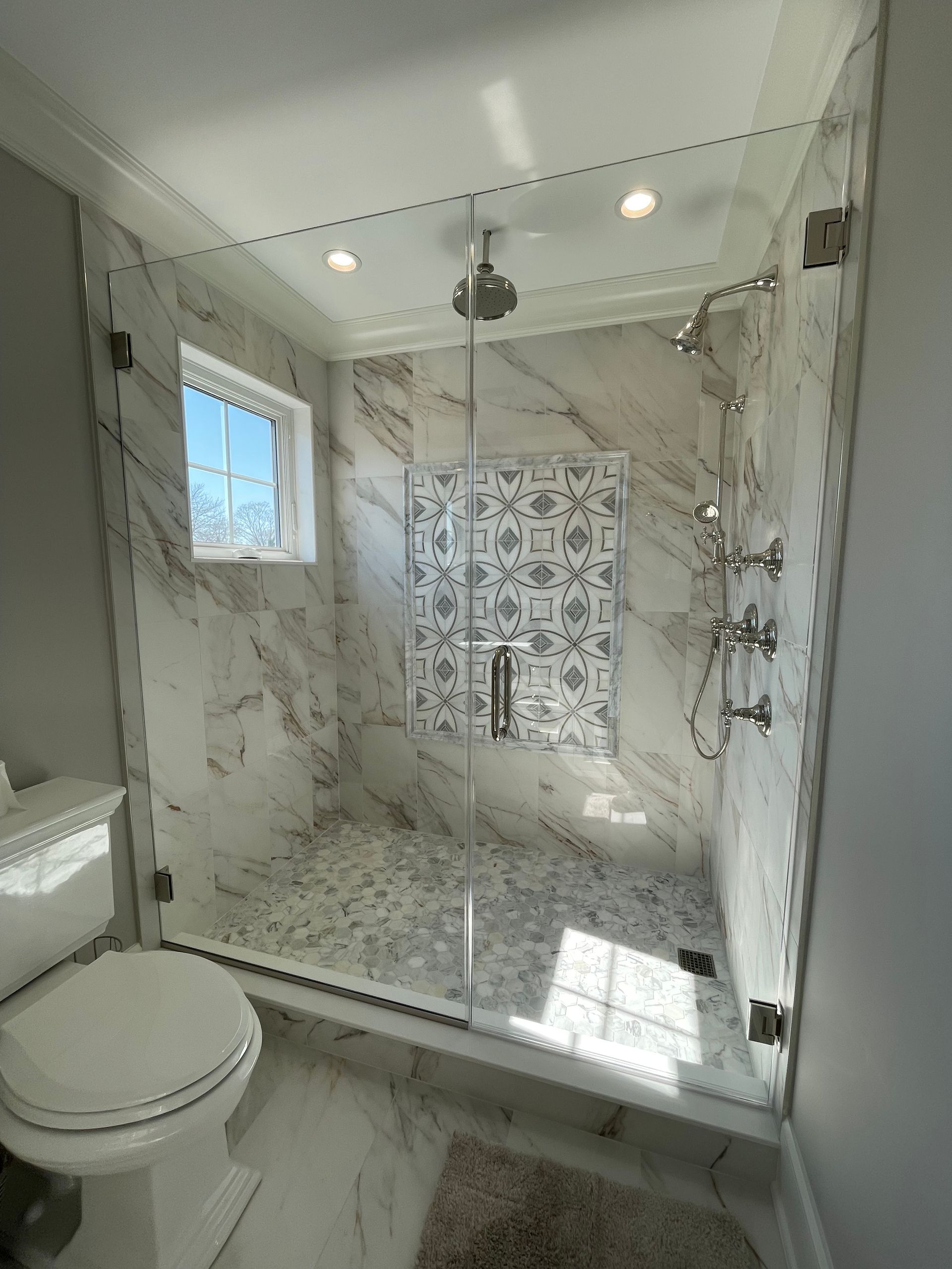 A bathroom with a walk in shower and a toilet.