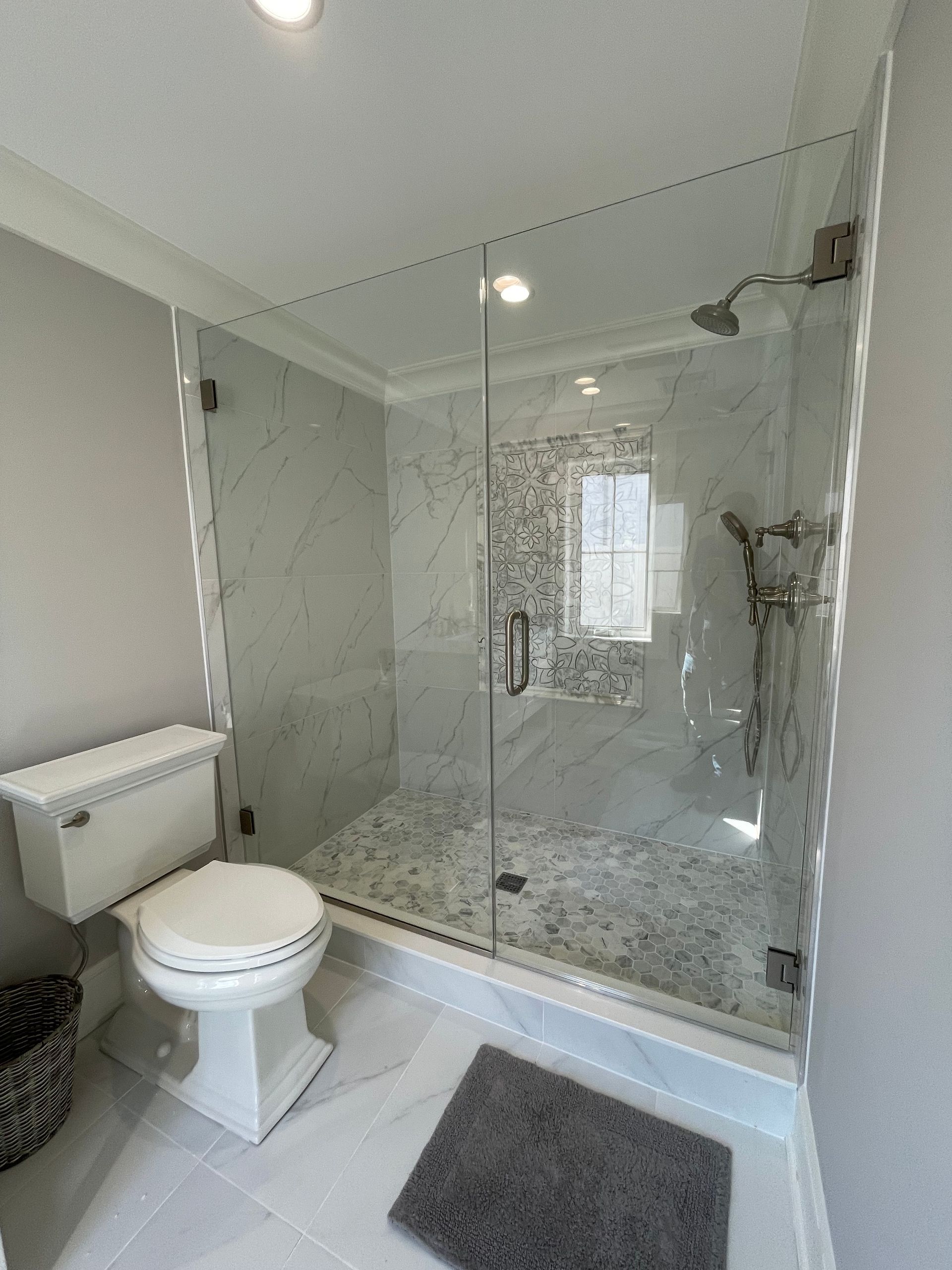 A bathroom with a toilet and a walk in shower.