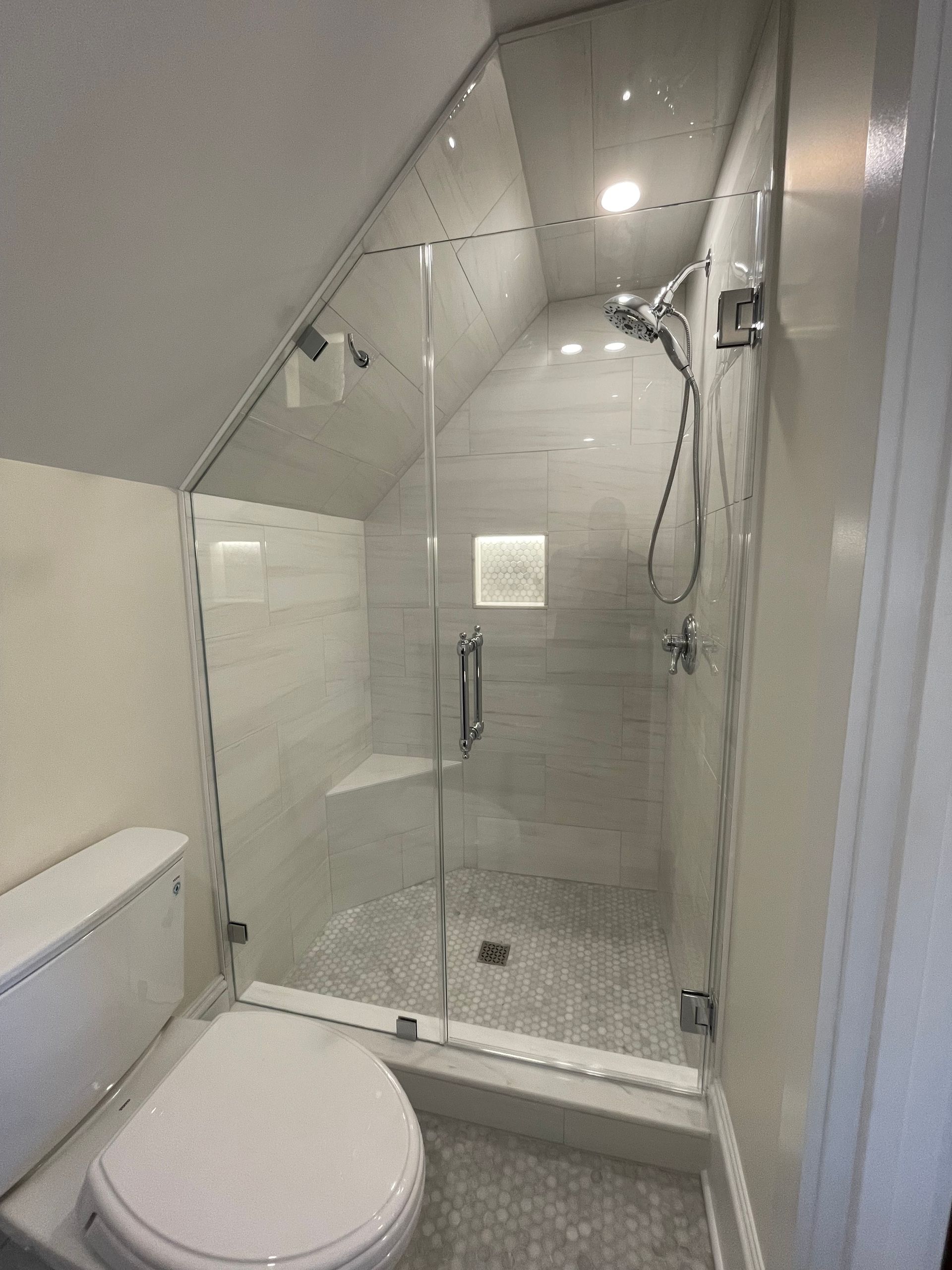 A bathroom with a toilet and a shower with a glass door.