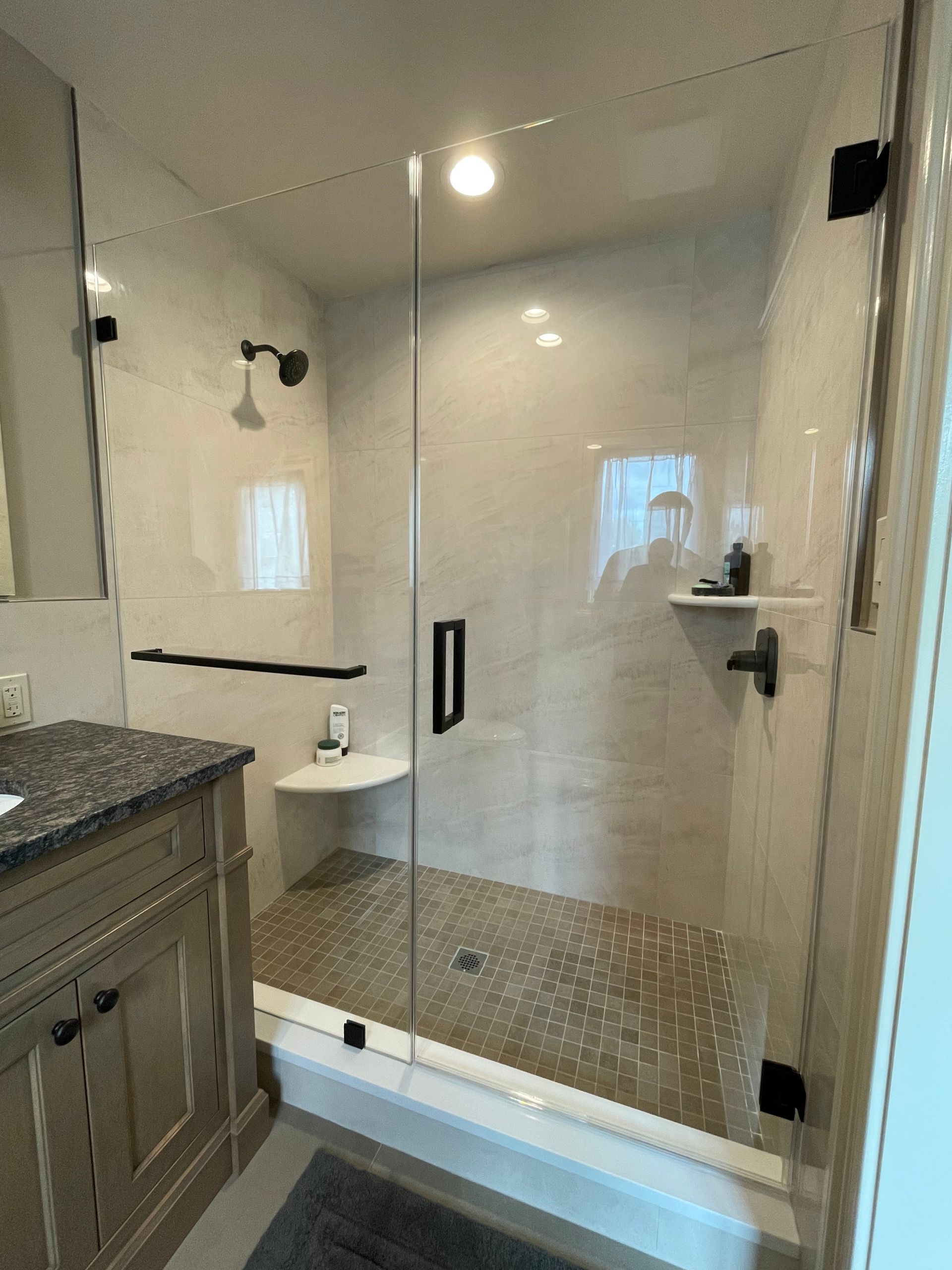 A bathroom with a walk in shower and a sink.