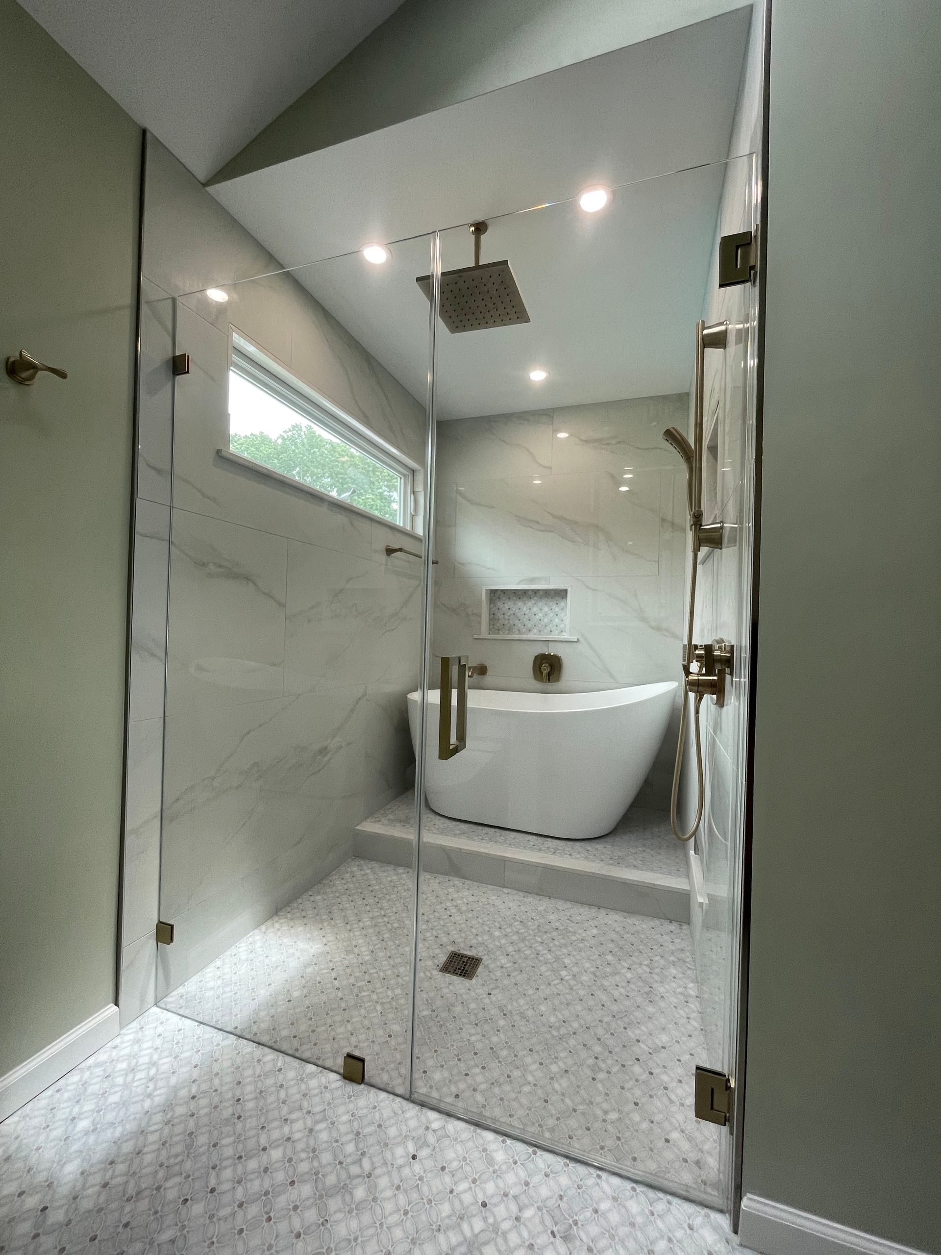 A bathroom with a bathtub and a glass shower door.