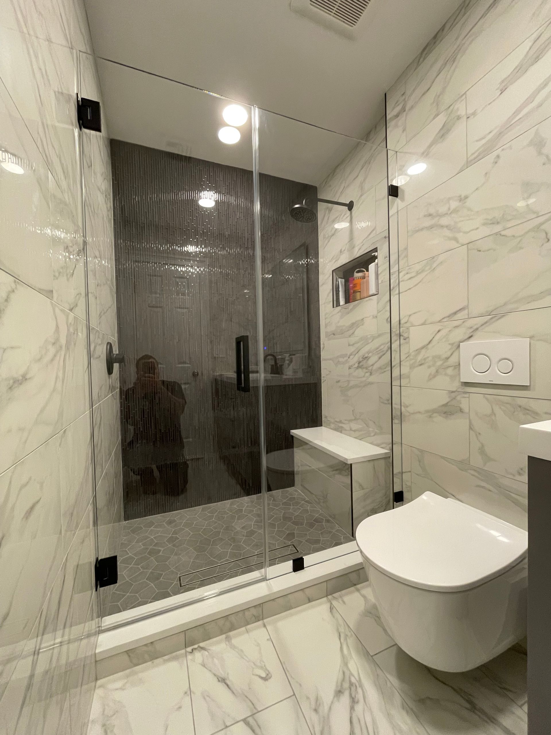 A bathroom with a toilet and a shower with a glass door.