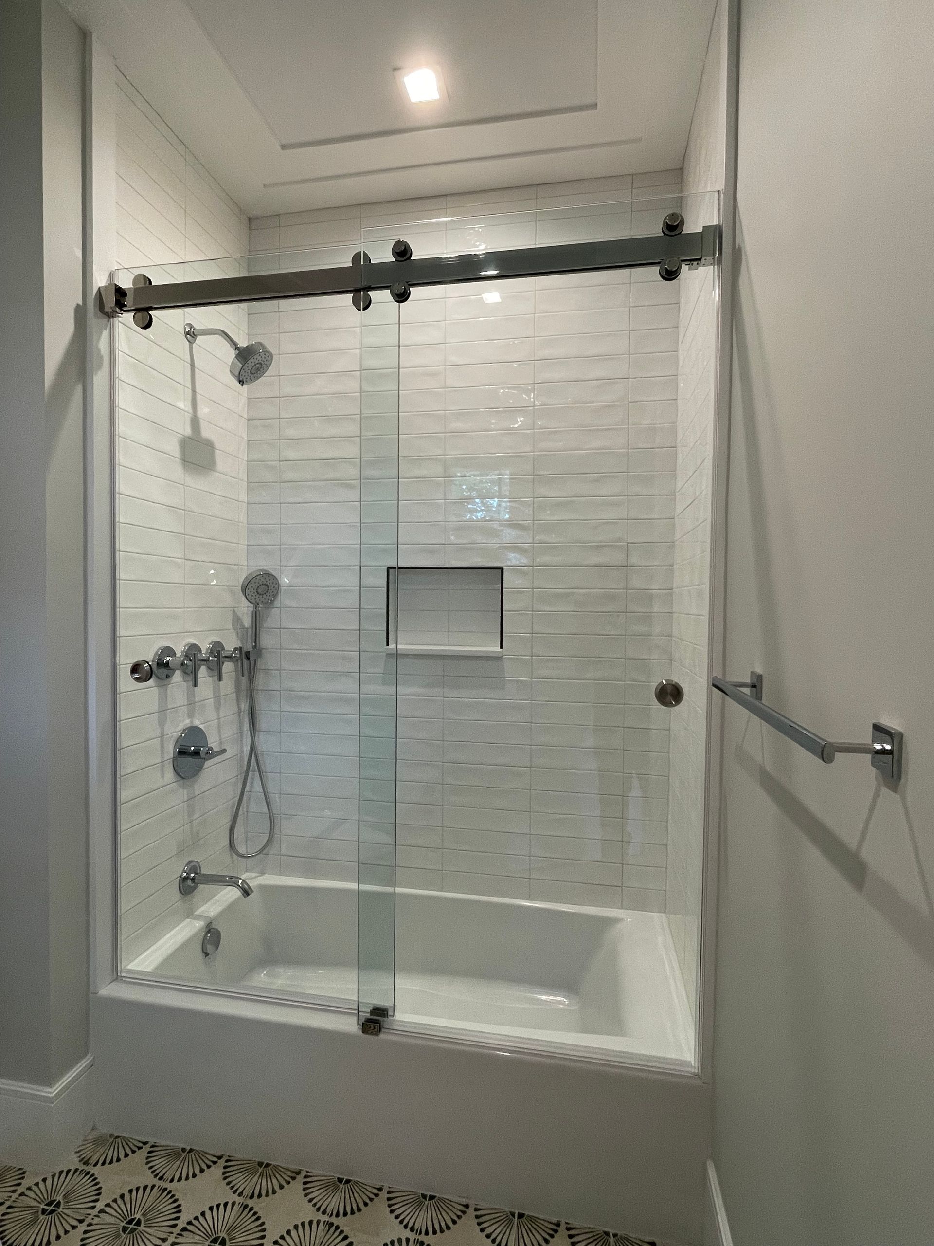 A bathroom with a bathtub and a shower with a sliding glass door.