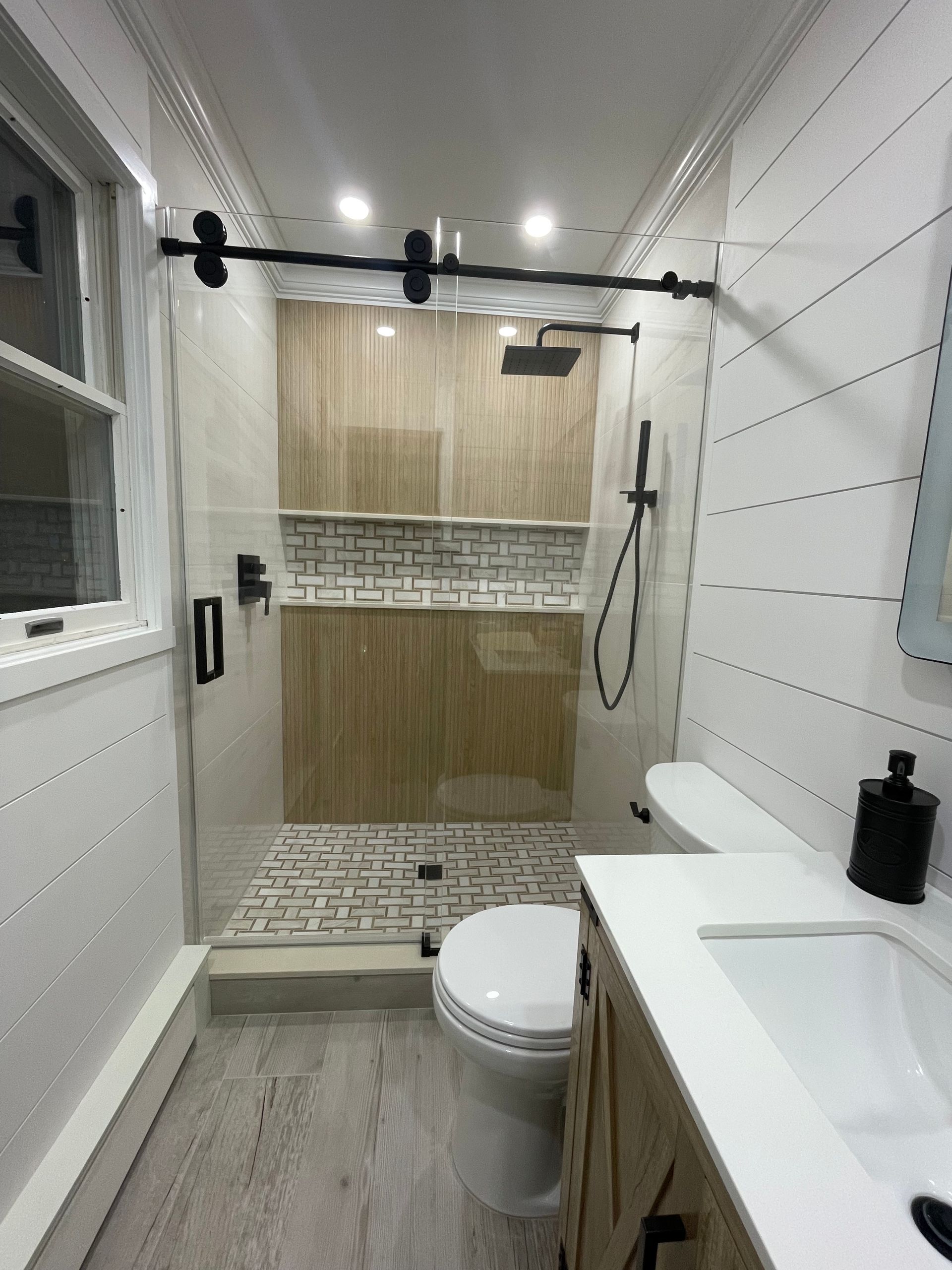 A bathroom with a toilet , sink and shower.