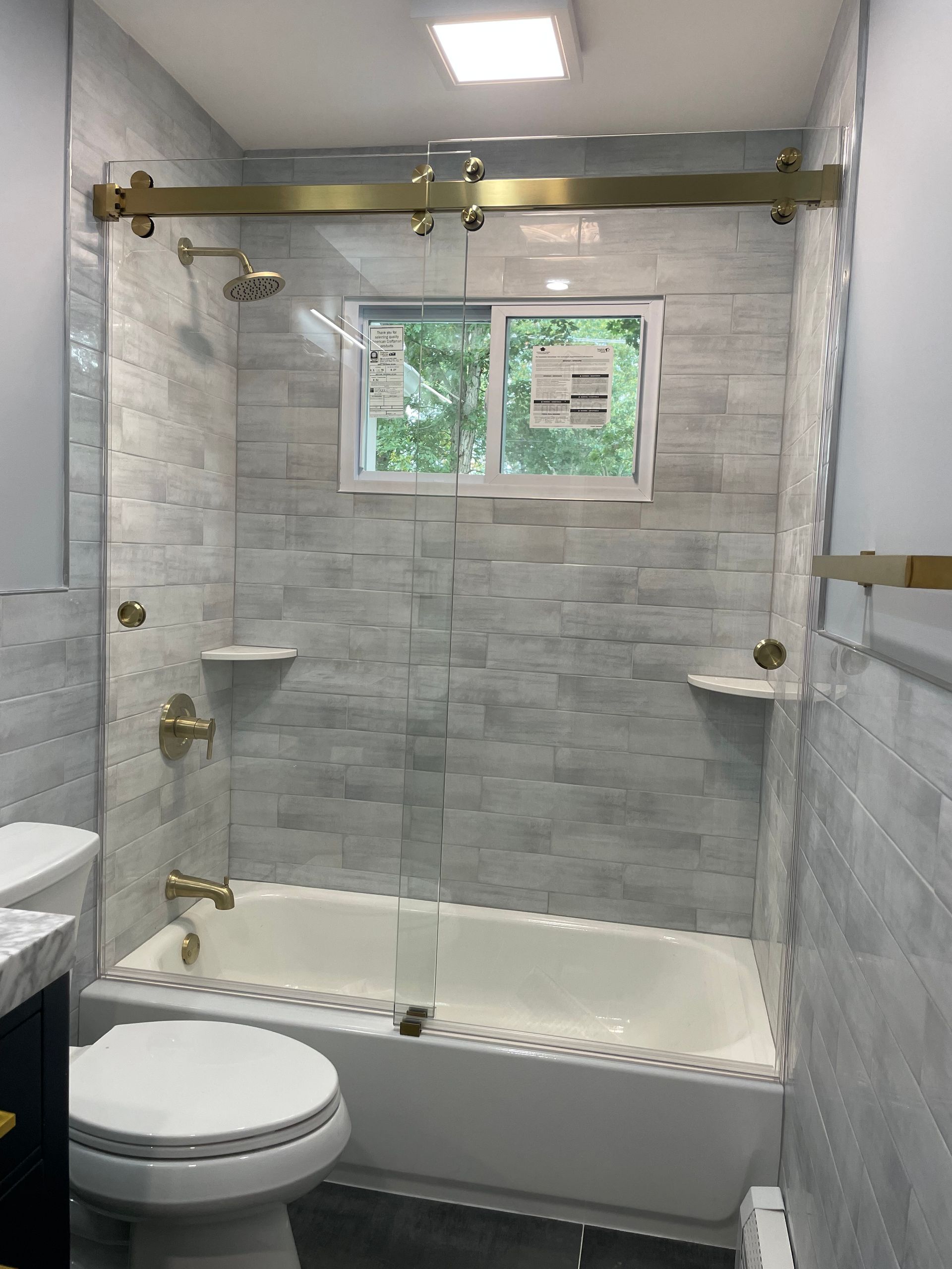 A bathroom with a tub , toilet , sink and shower.