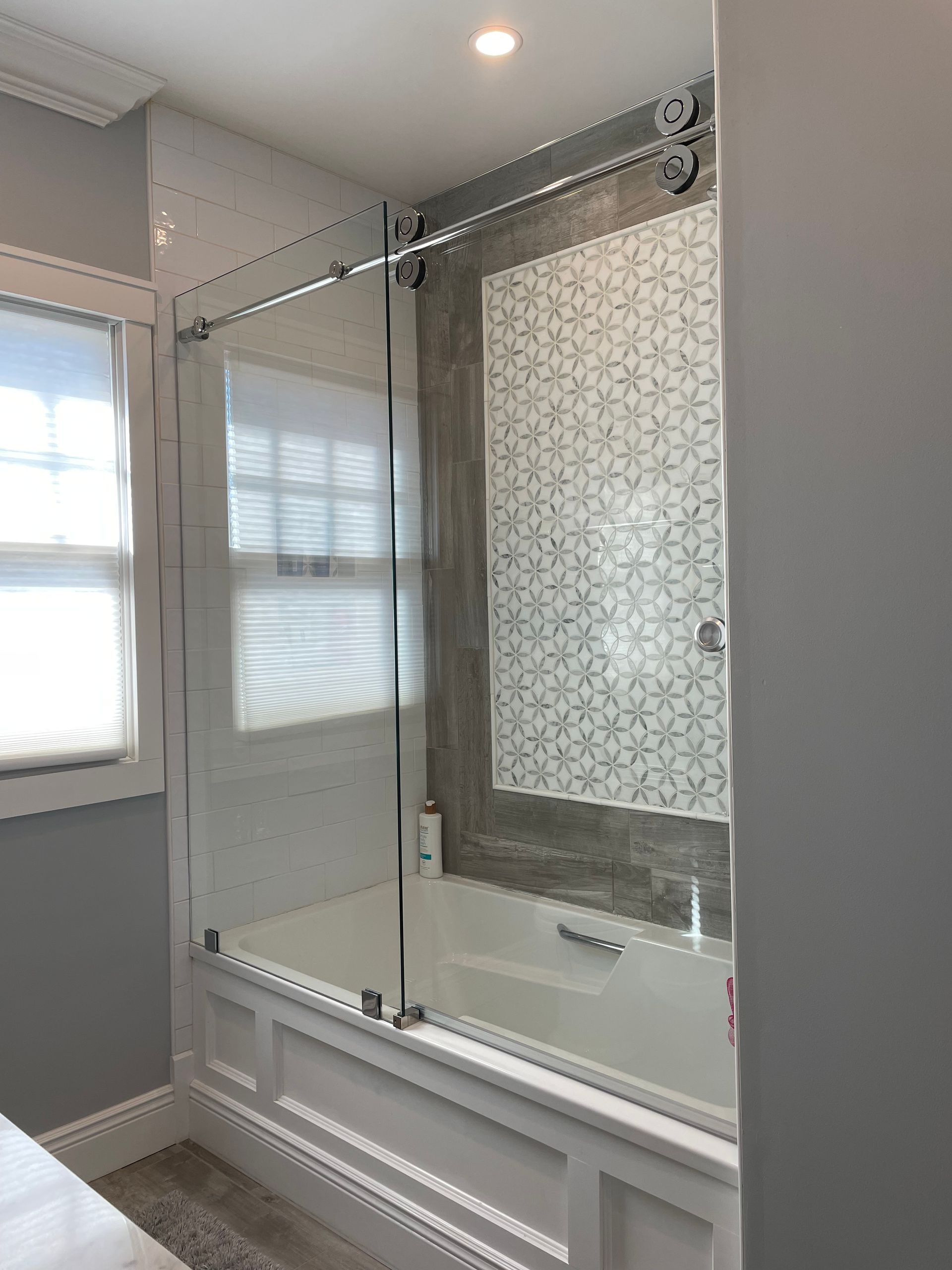 A bathroom with a bathtub and a sliding glass shower door.