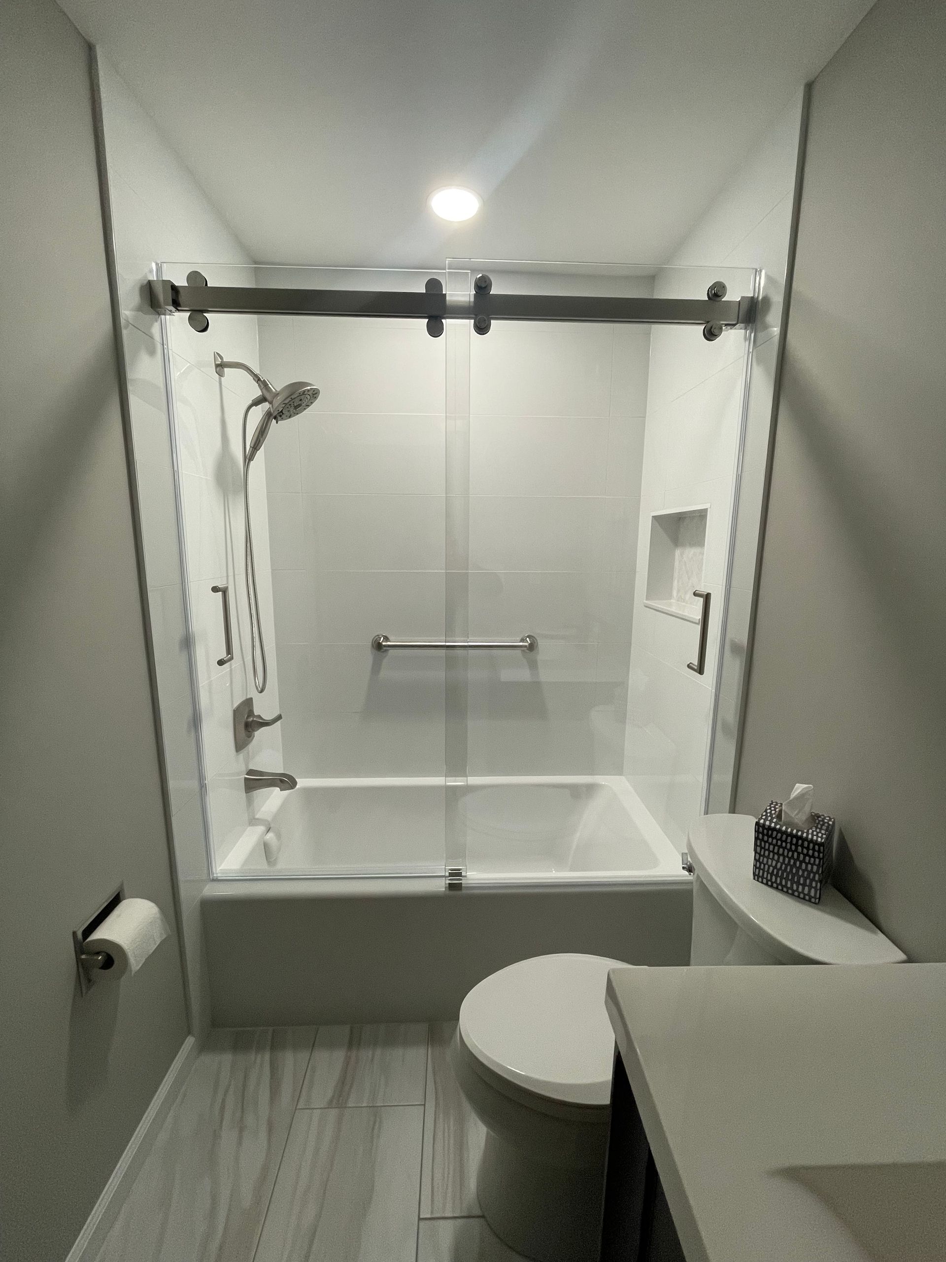 A bathroom with a tub , toilet , sink and shower.
