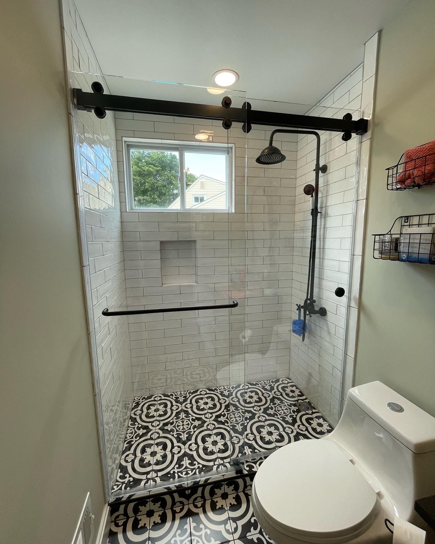 A bathroom with a toilet and a shower with a sliding glass door.