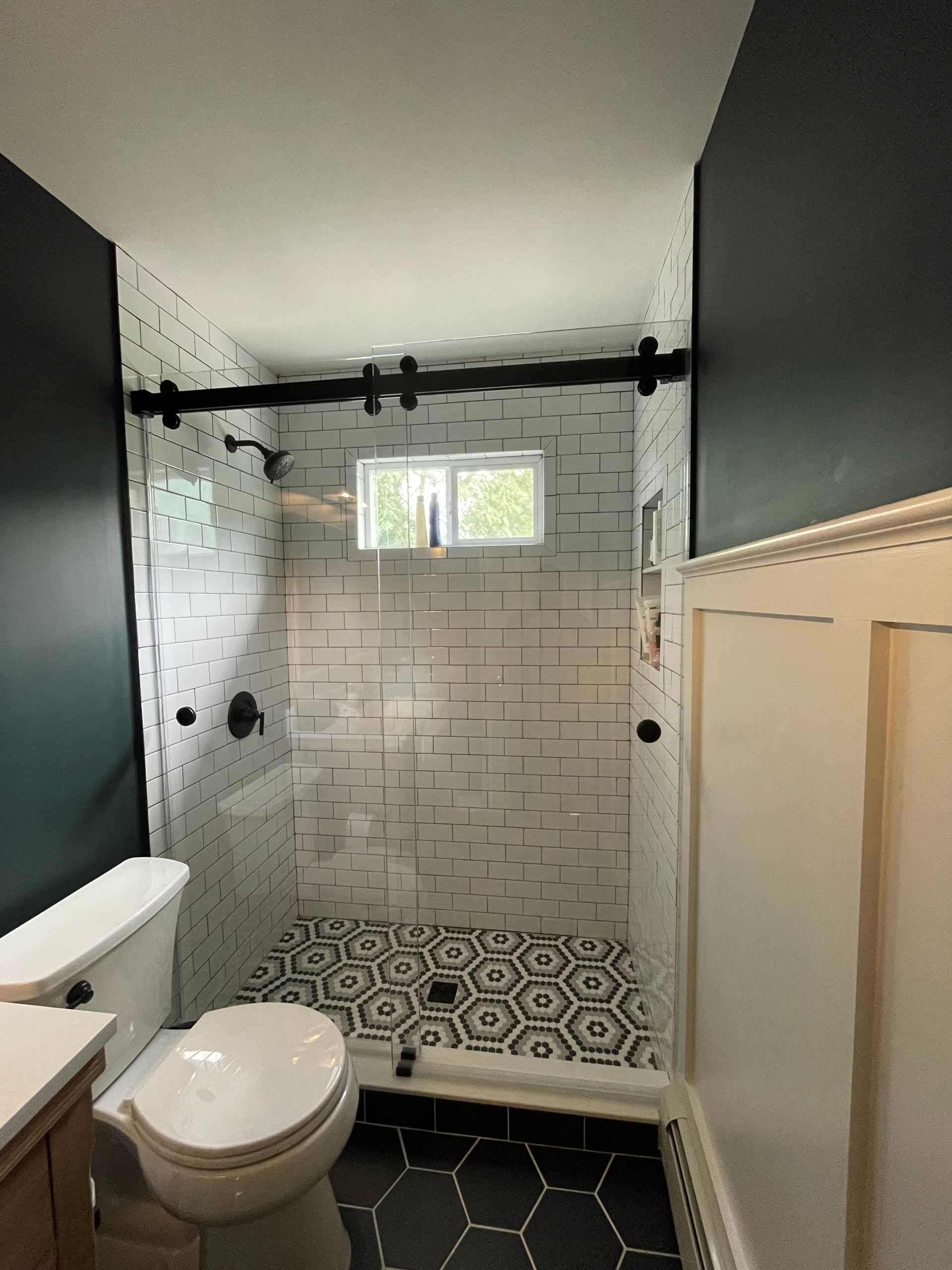 A bathroom with a toilet , sink and shower.