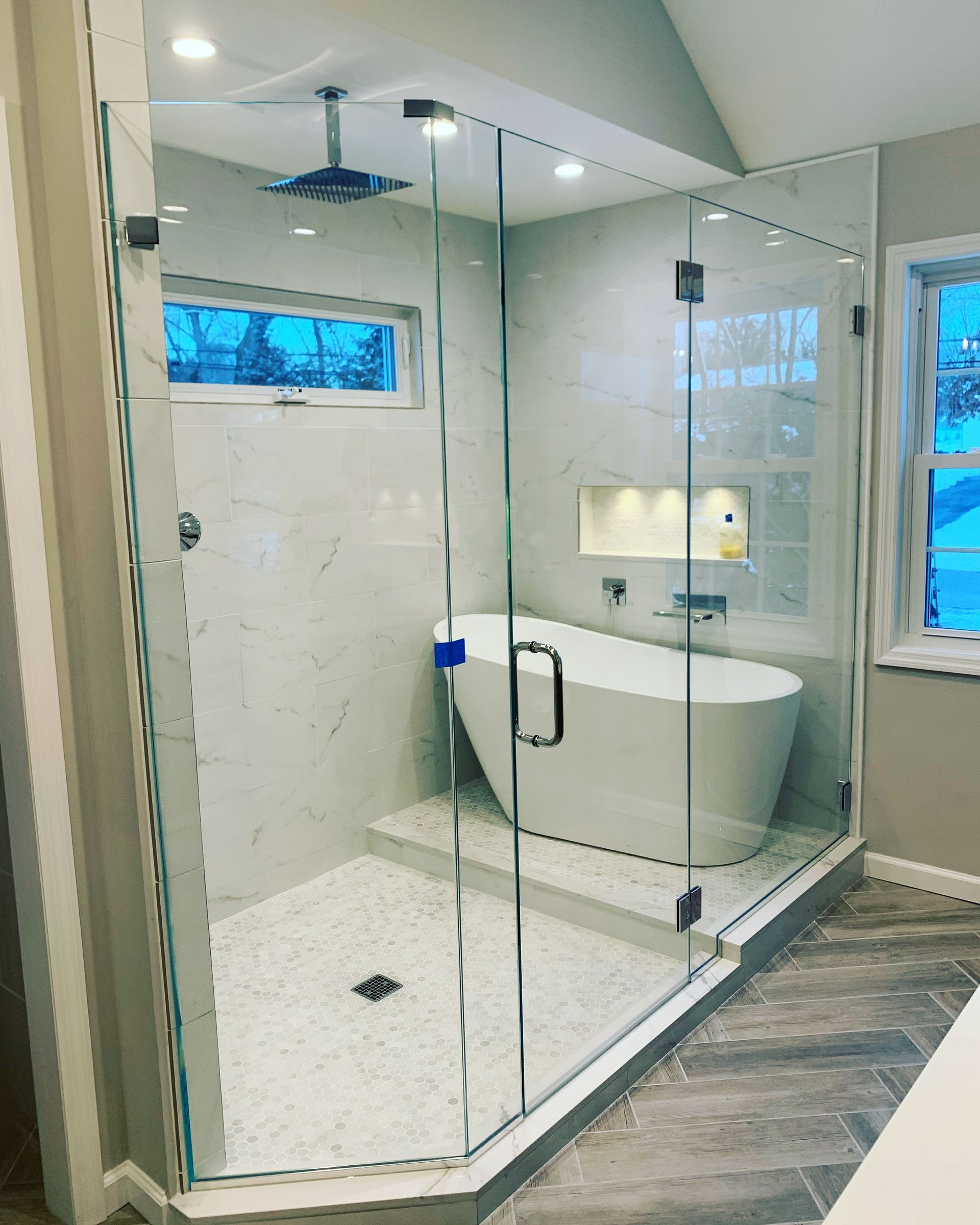 A bathroom with a tub and a shower with a glass door.