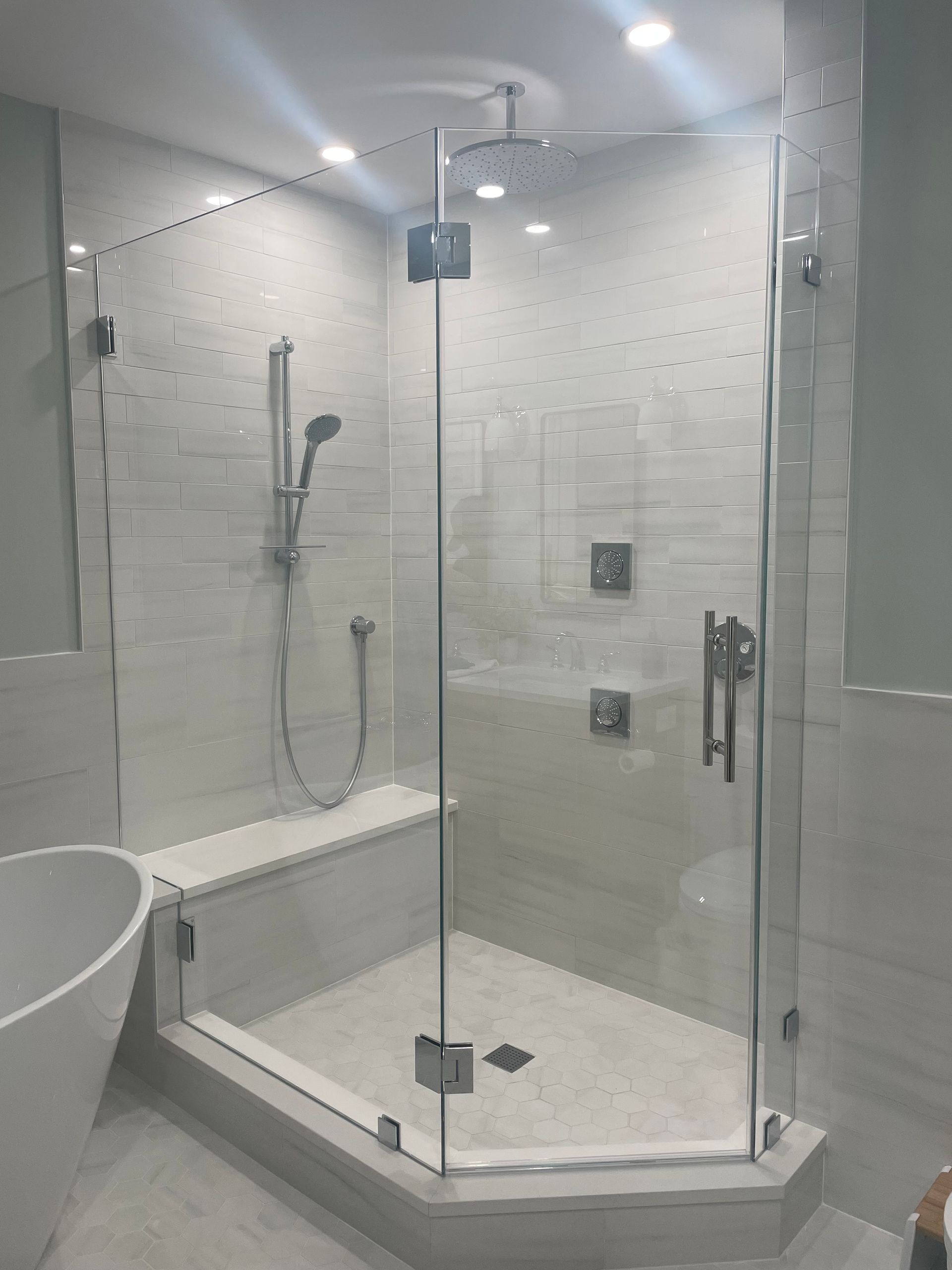 A bathroom with a walk in shower and a bathtub.