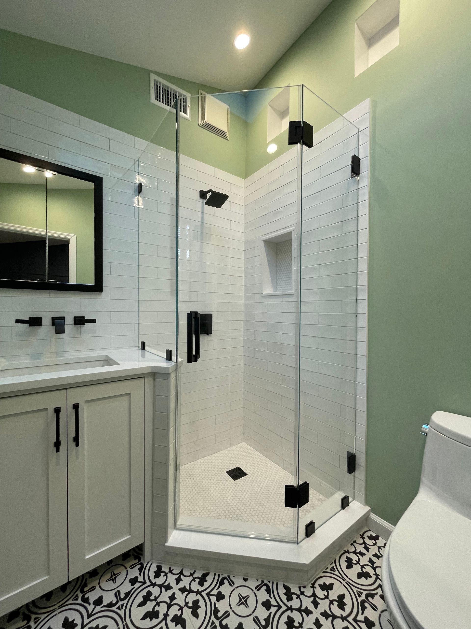 A bathroom with a walk in shower and a toilet