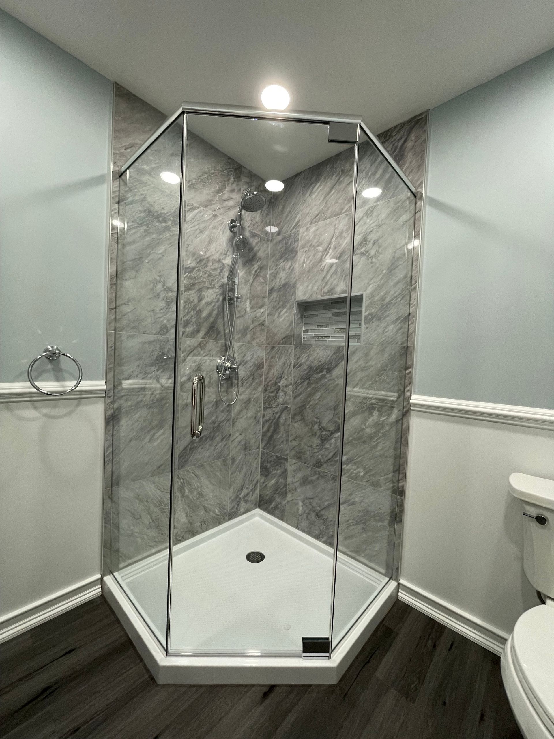 A bathroom with a shower stall and a toilet.