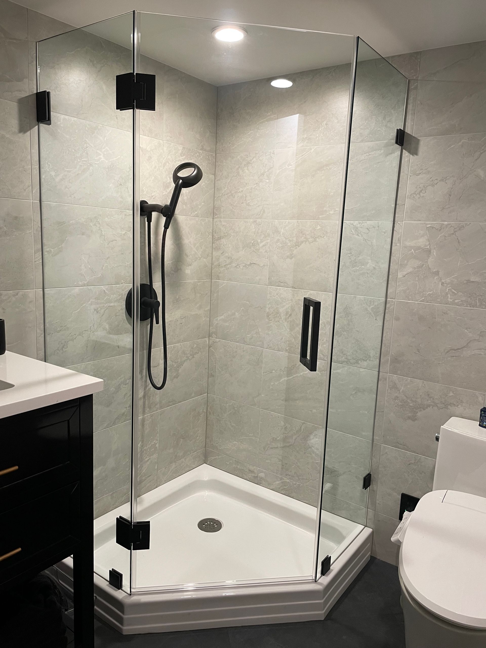 A bathroom with a walk in shower and a toilet.