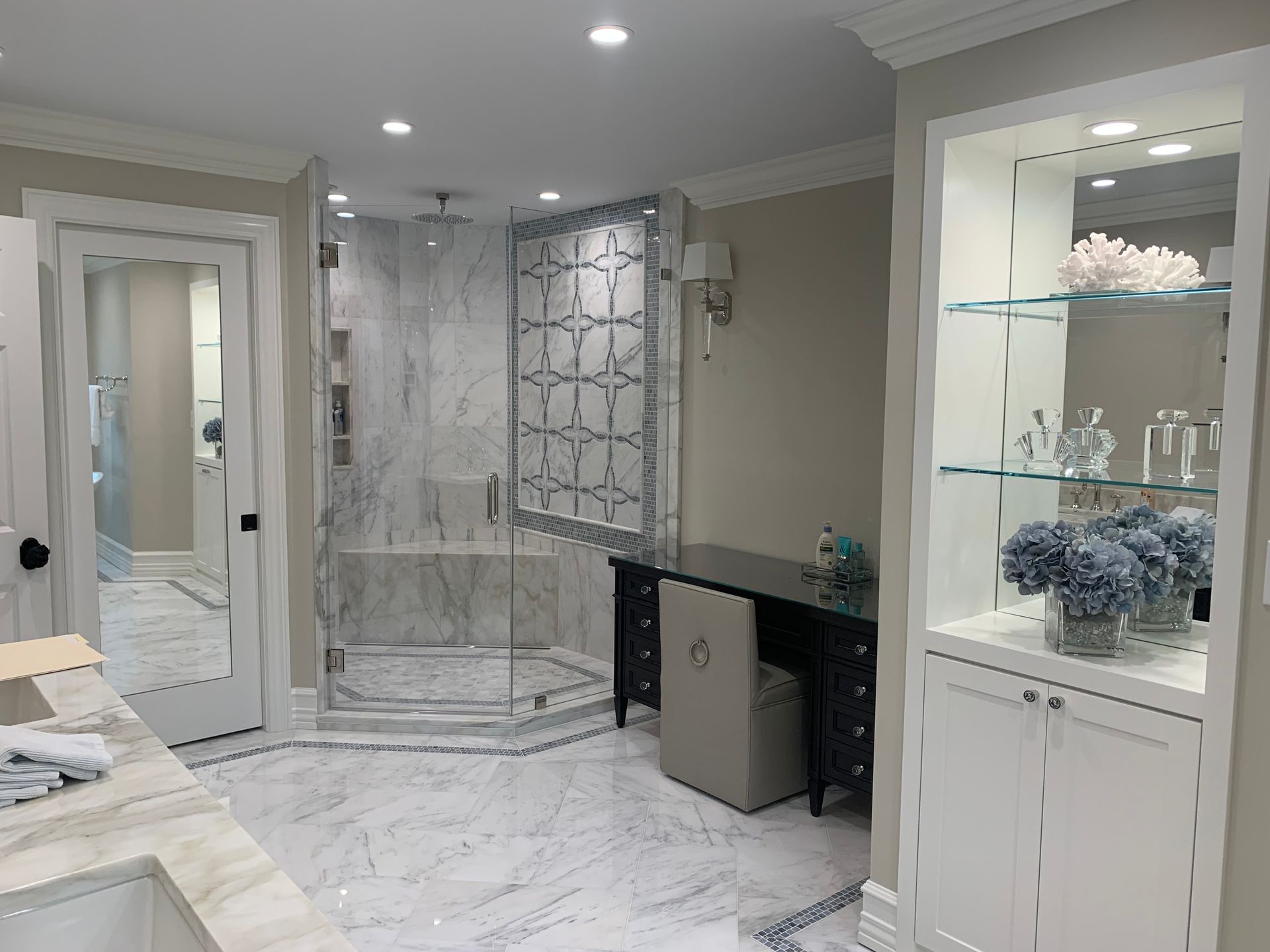 A bathroom with a walk in shower and a sink.