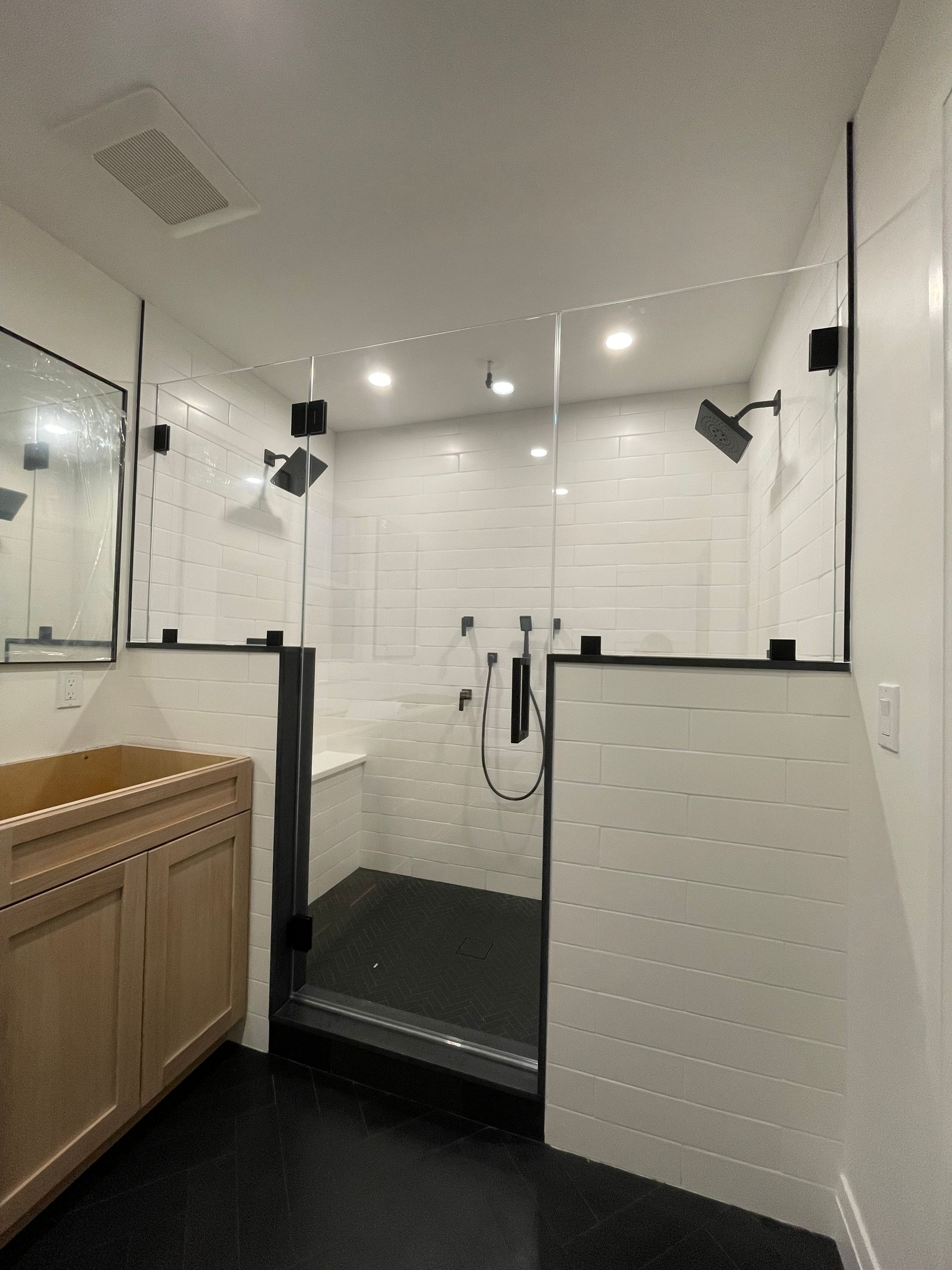 A bathroom with a walk in shower and a sink