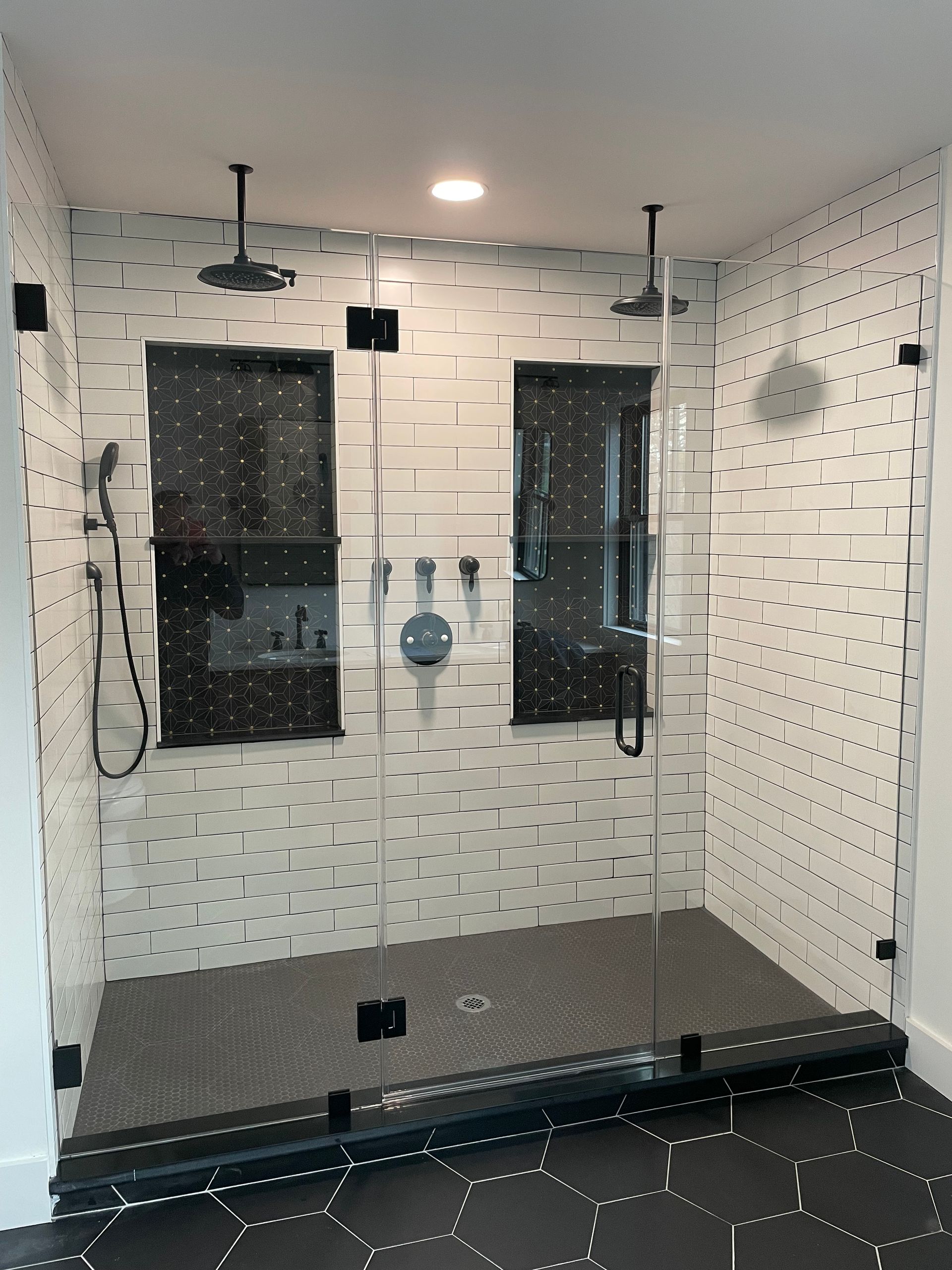 A bathroom with a walk in shower with a glass door