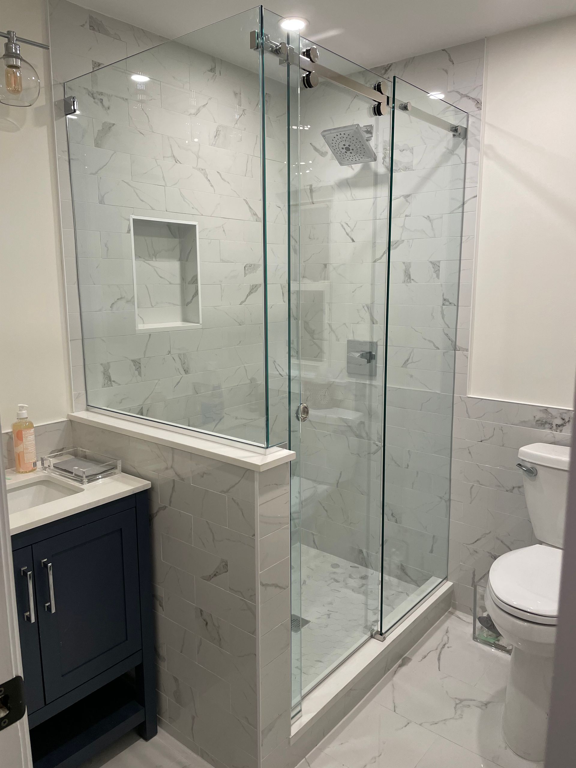 A bathroom with a toilet , sink , and walk in shower.