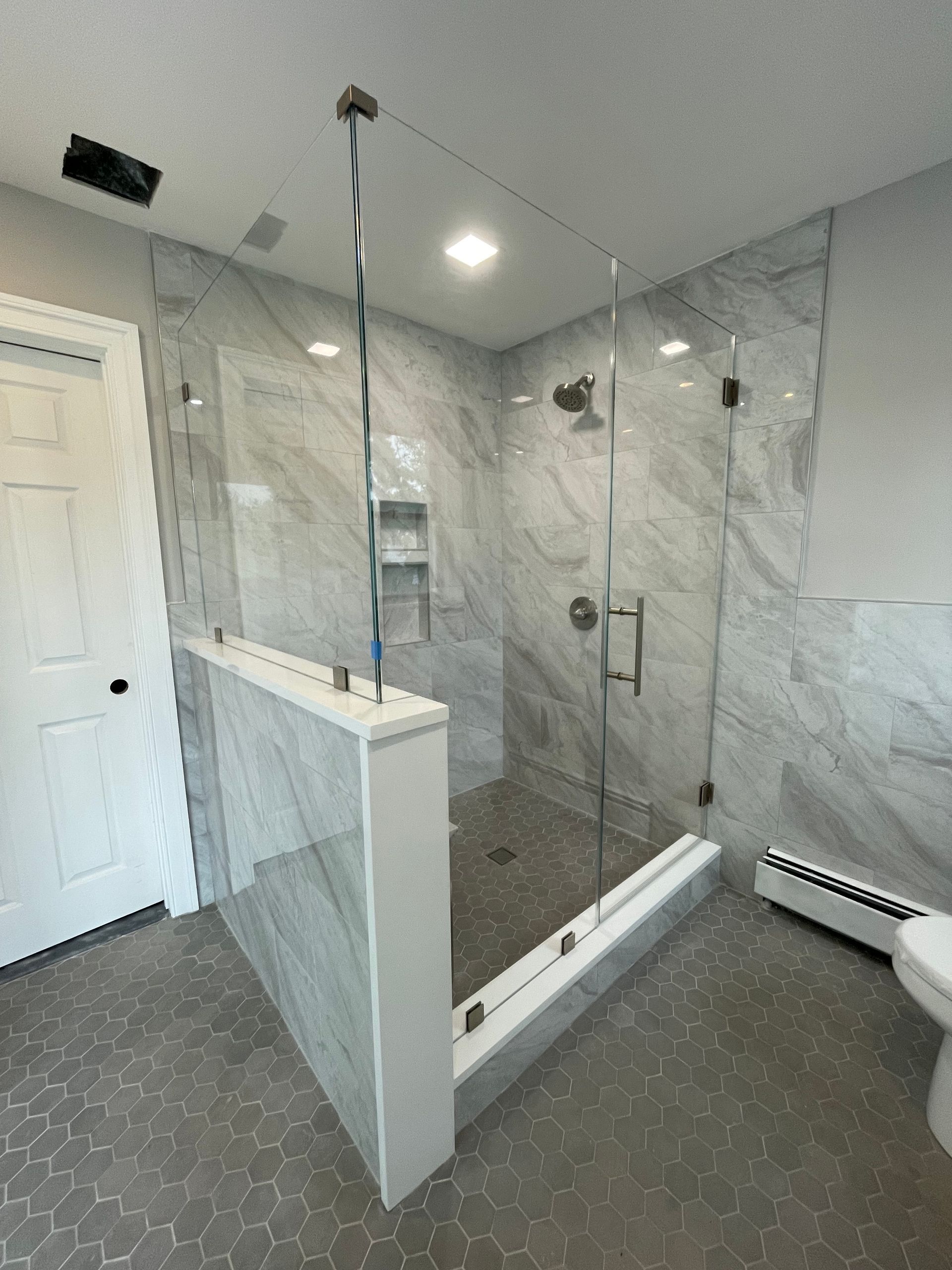 A bathroom with a walk in shower and a toilet.