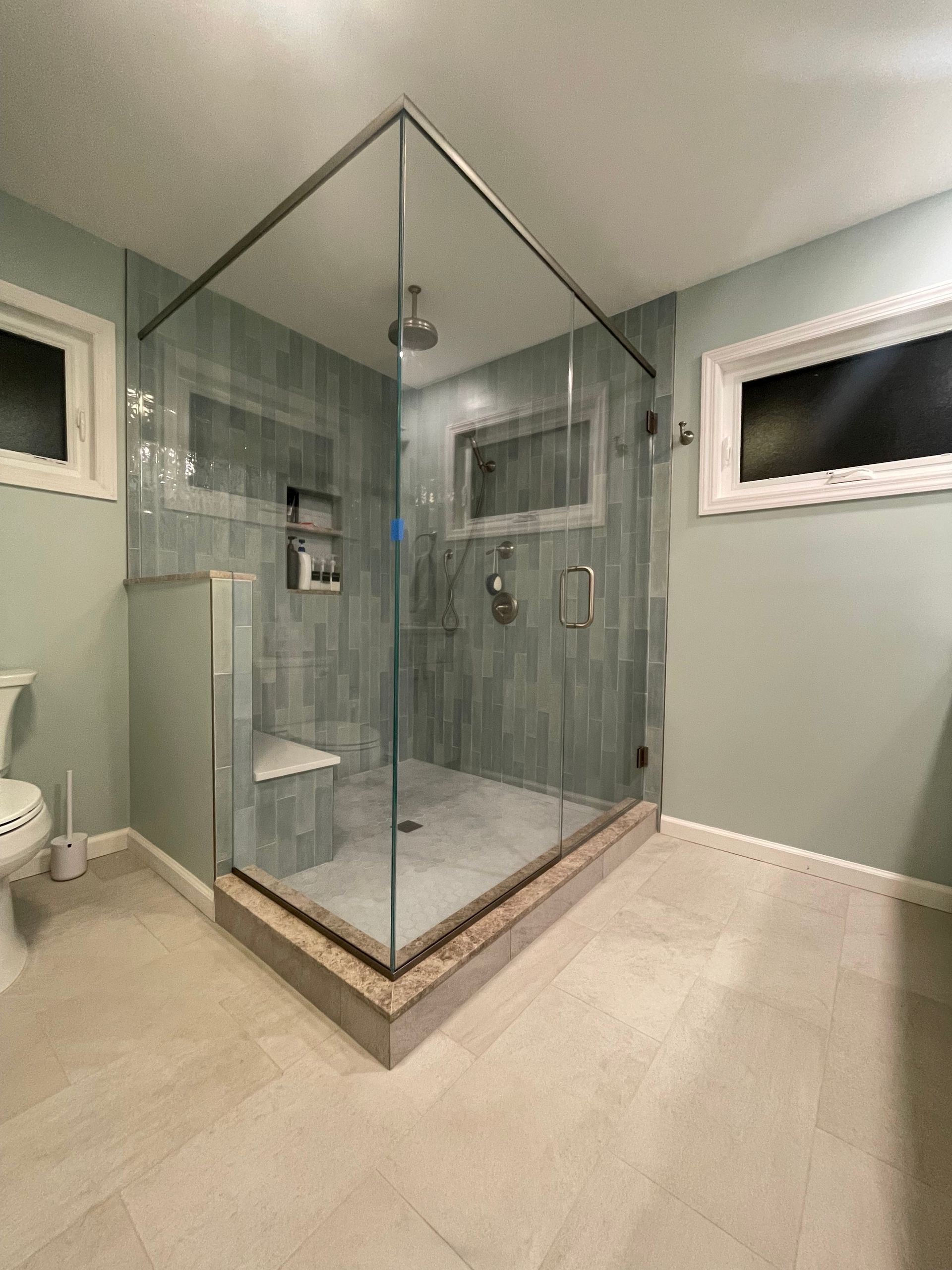 A bathroom with a walk in shower and a toilet.