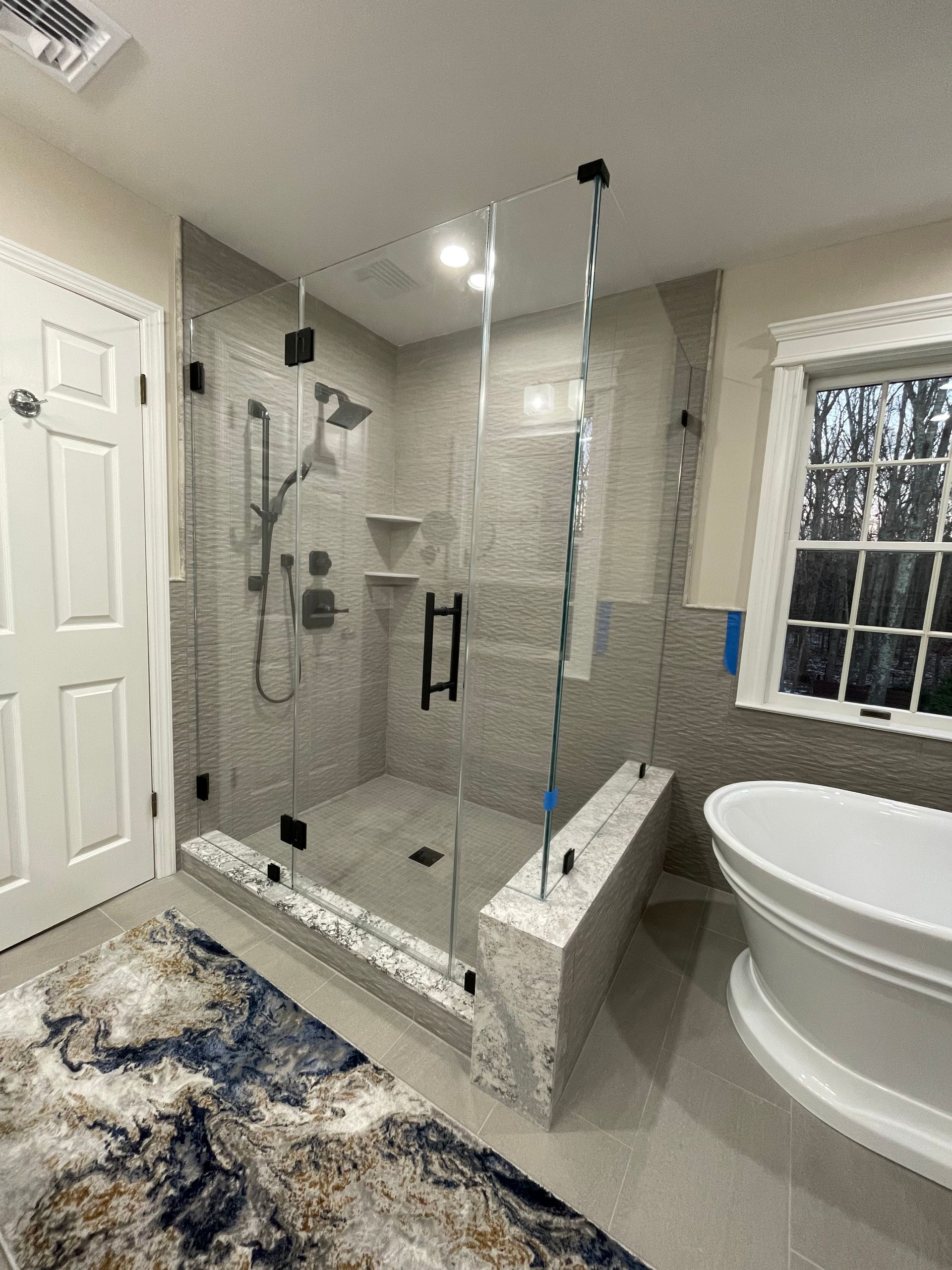 A bathroom with a tub , shower , and window.