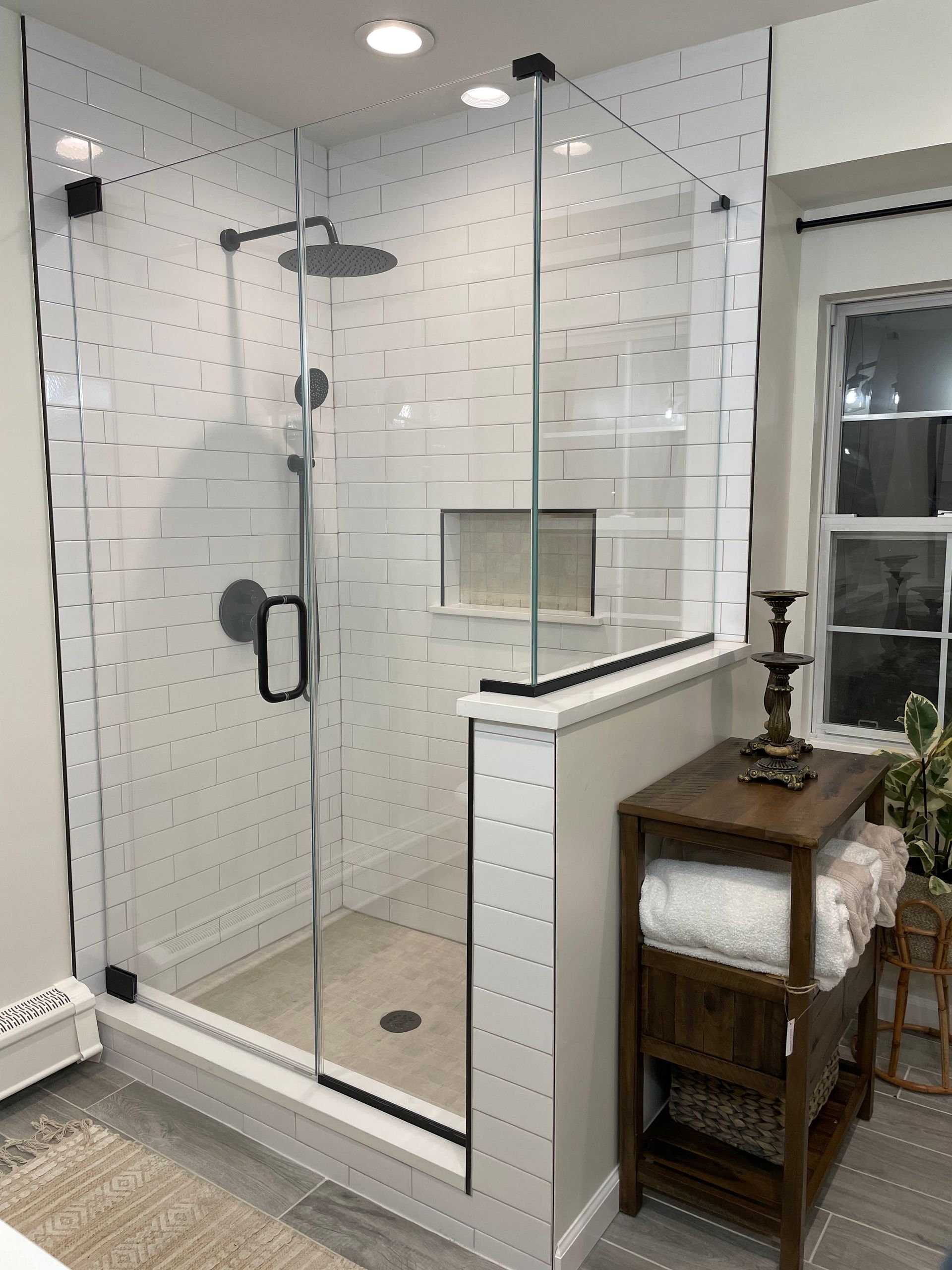 A bathroom with a walk in shower with a glass door