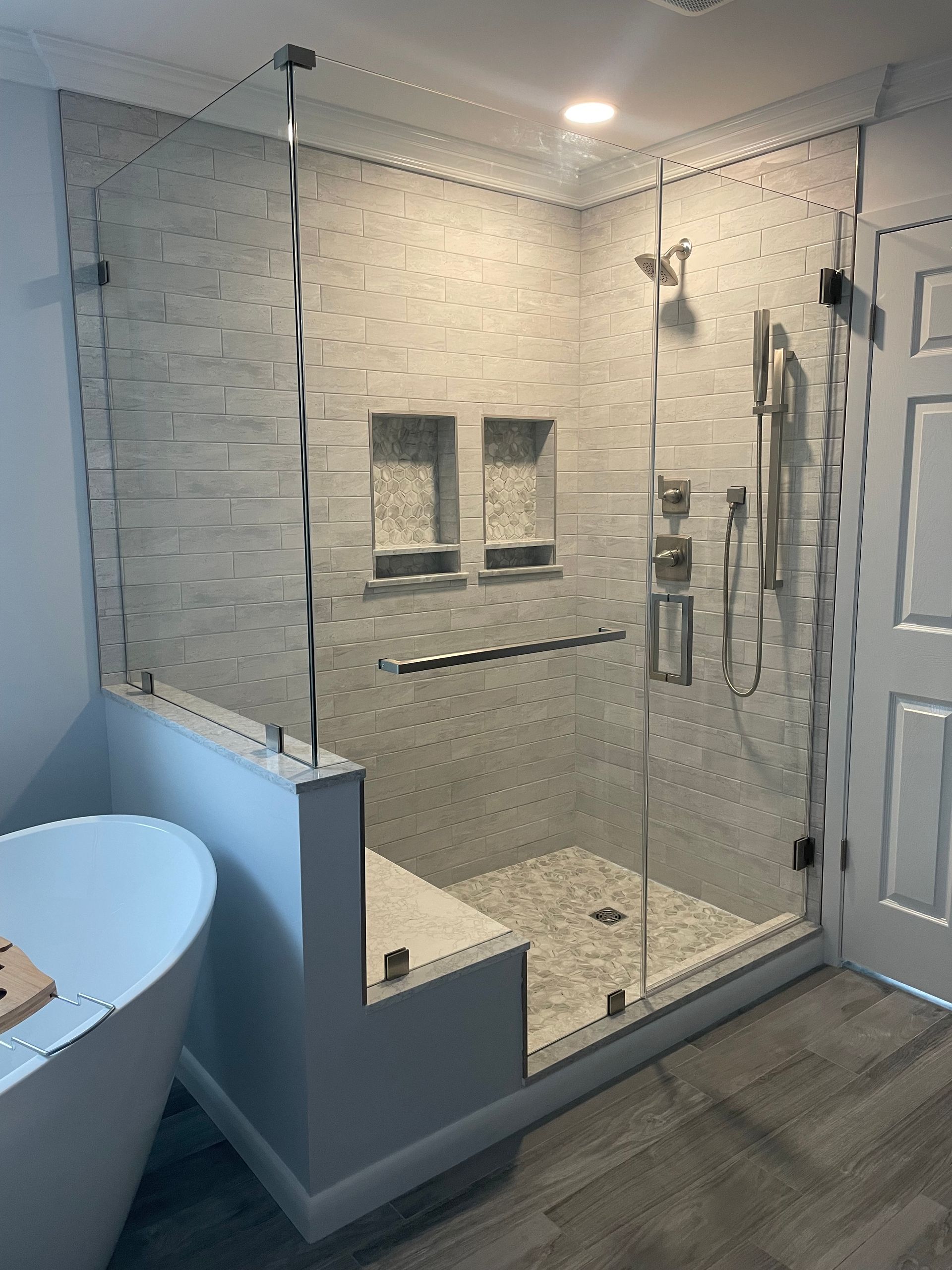 A bathroom with a walk in shower and a bathtub.