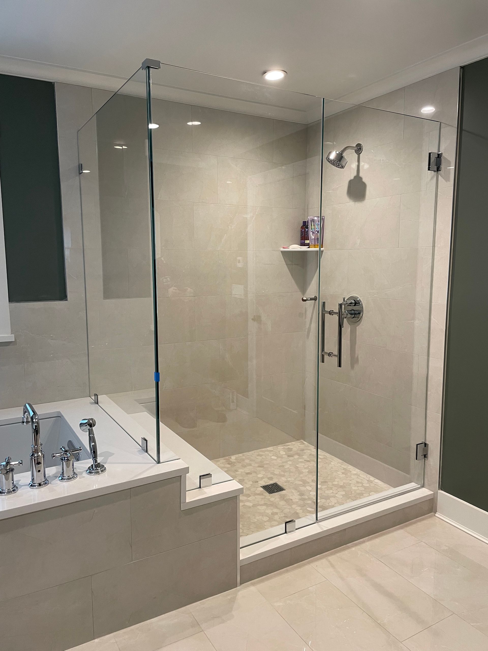 A bathroom with a tub , shower , and glass door.