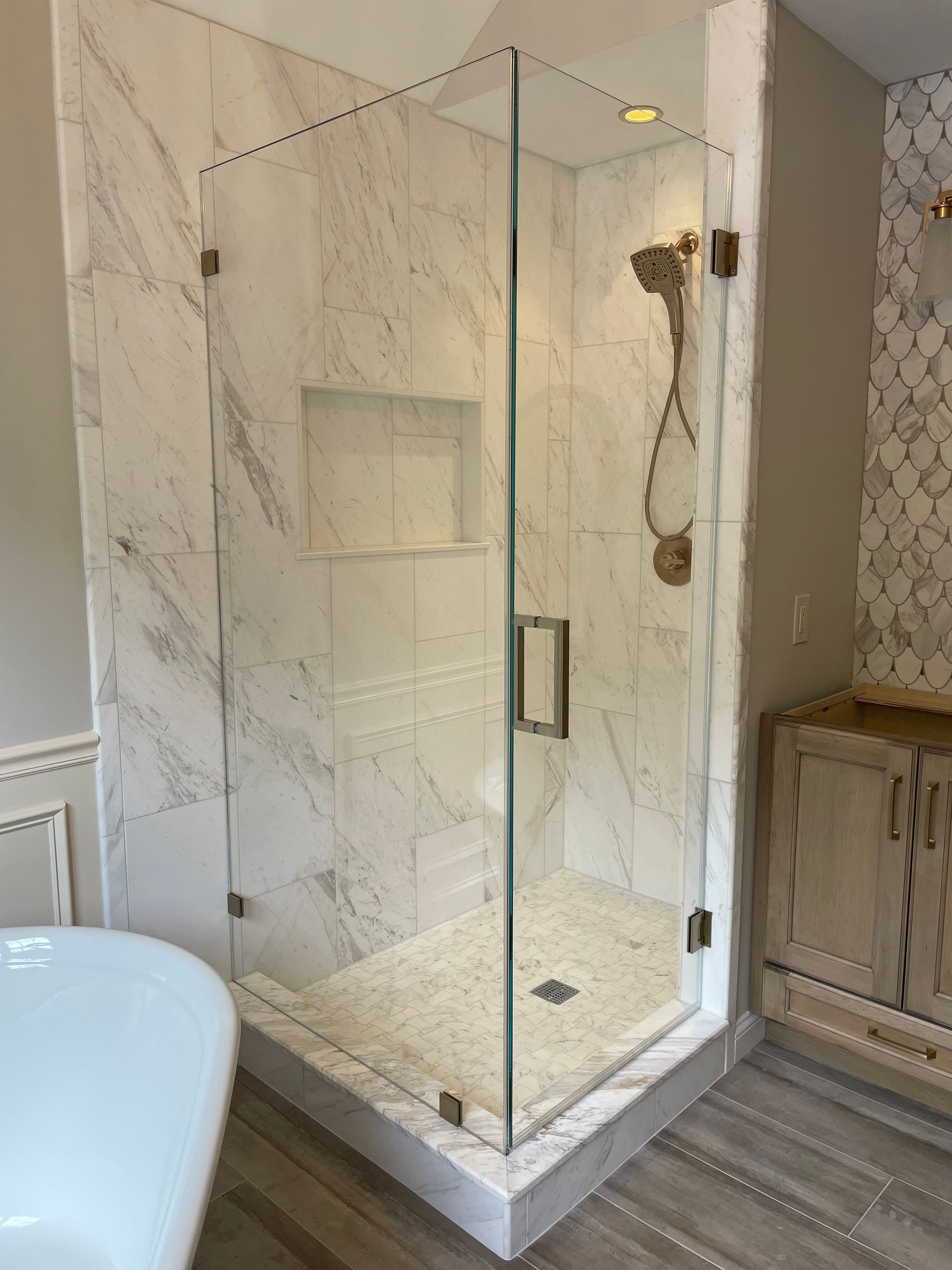 A bathroom with a walk in shower and a bathtub.