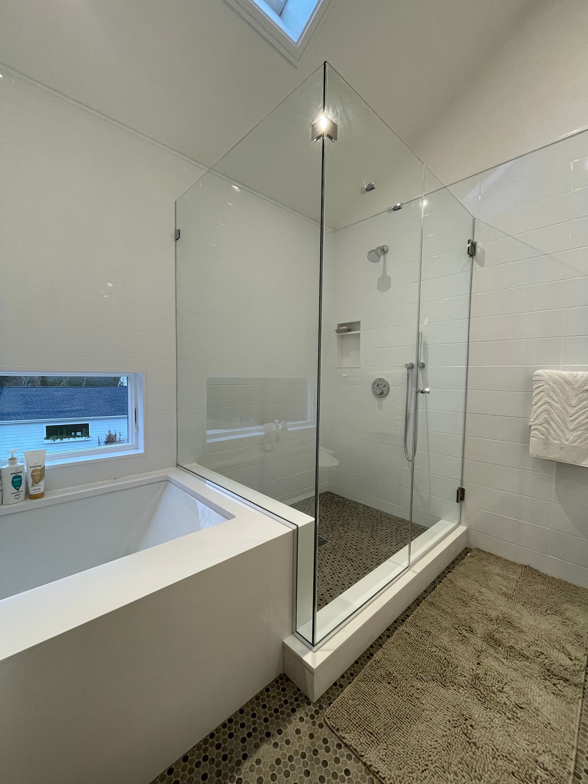 A bathroom with a bathtub and a walk in shower