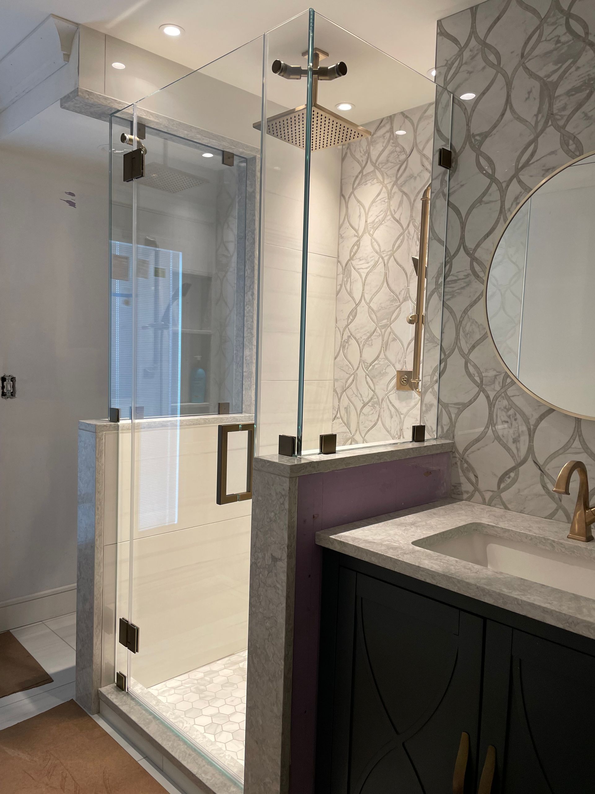 A bathroom with a sink , shower , and mirror.