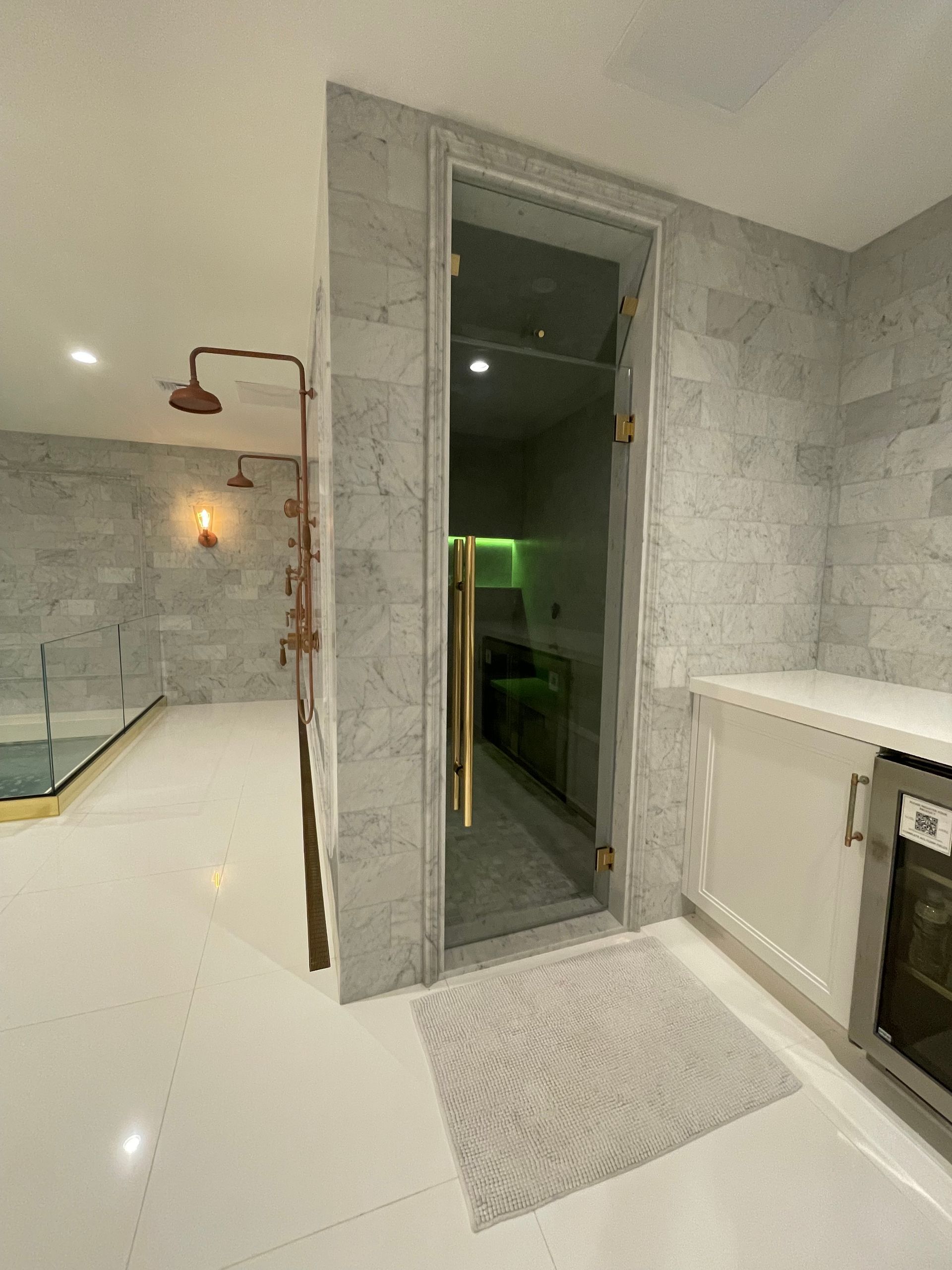A bathroom with a glass door and a shower head