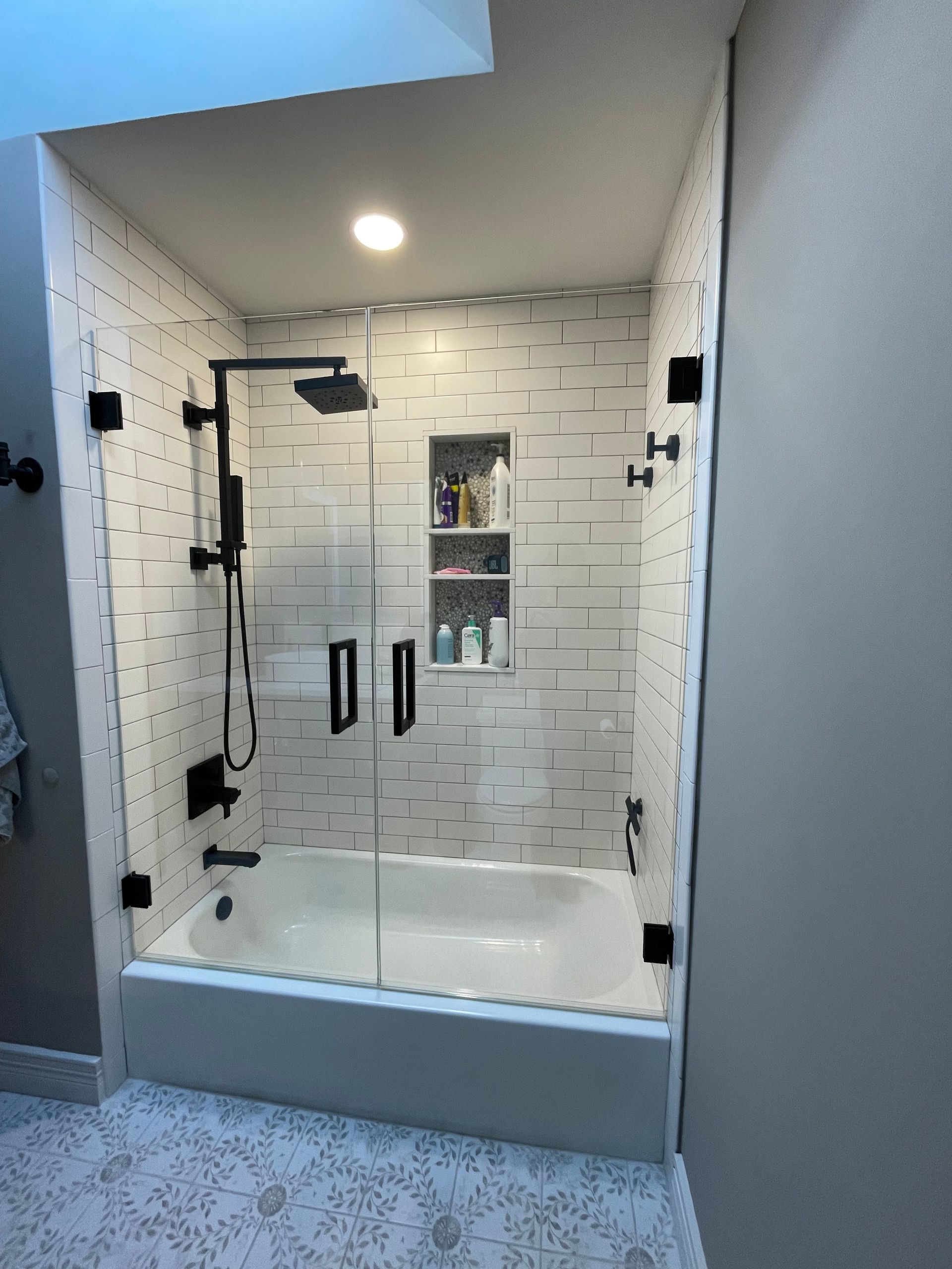 A bathroom with a bathtub and a shower with a glass door