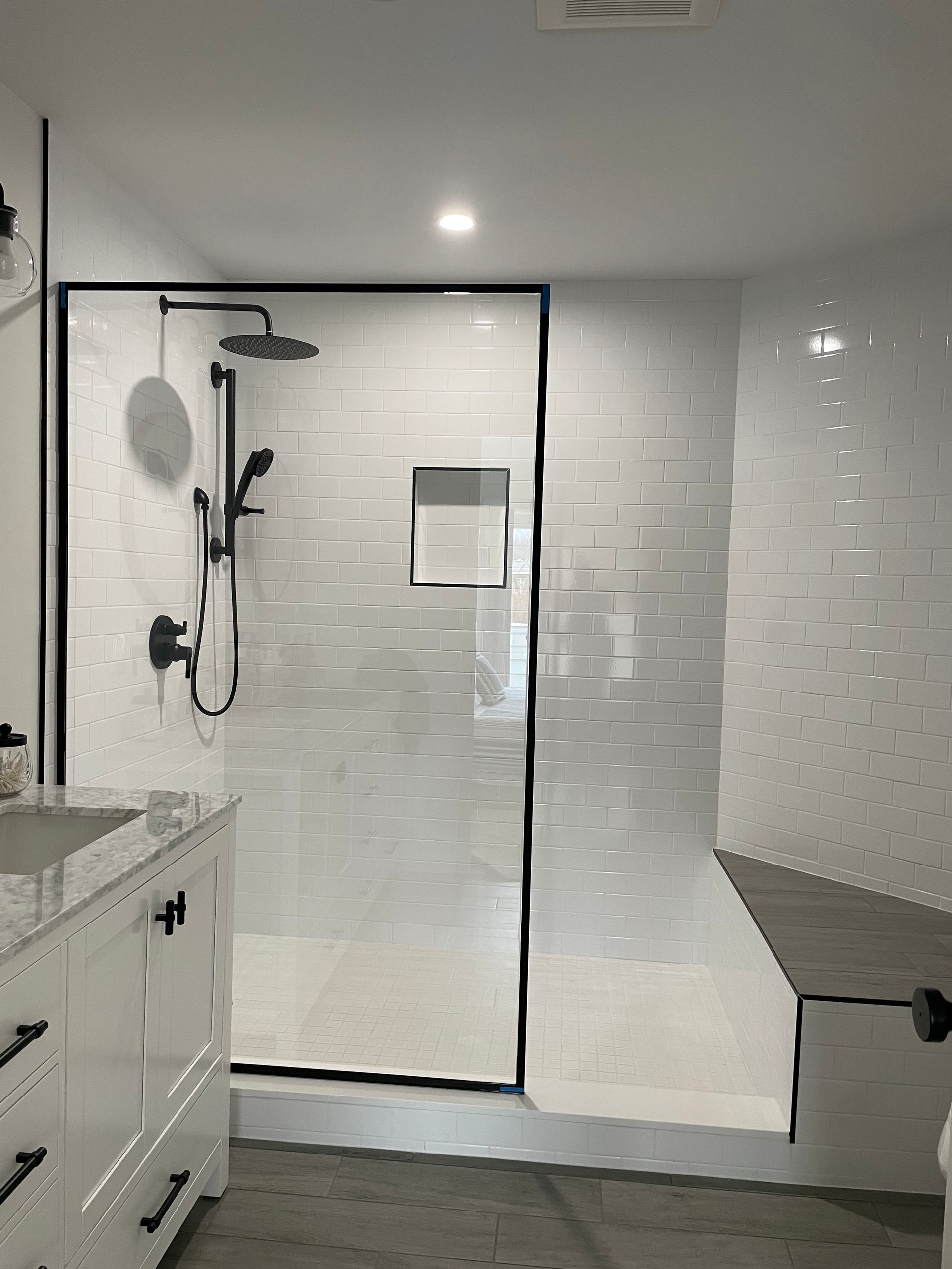 A bathroom with a walk in shower , sink , and mirror.